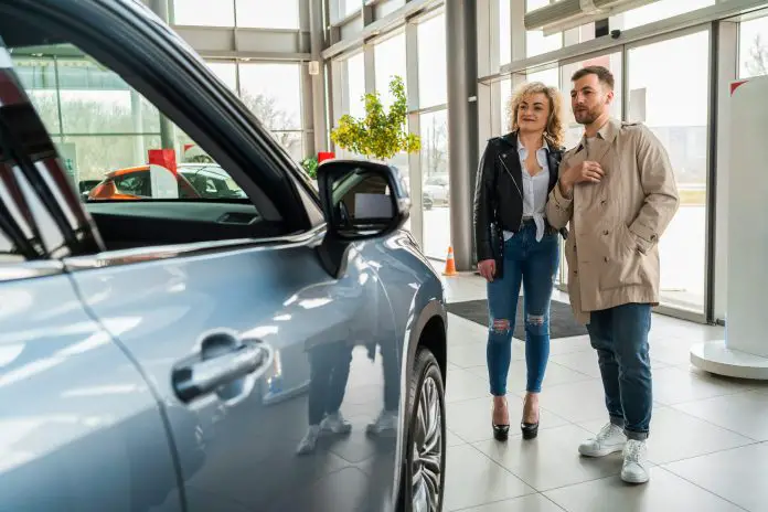 Beautiful couple in car dealership chooses car