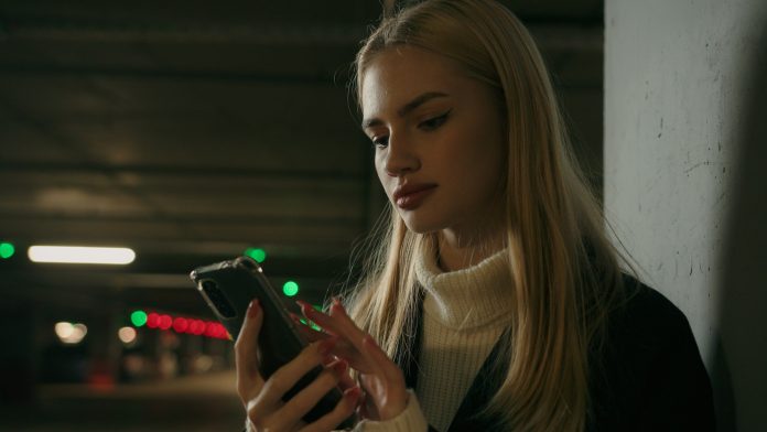 Businesswoman Caucasian woman female girl driver stand alone on parking use mobile phone texting