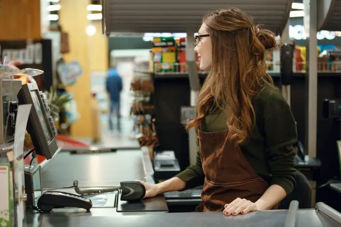 Cashier woman on workspace in supermarket shop