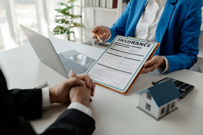 House insurance paperwork, A realtor is explaining home insurance documents to a buyer in his office