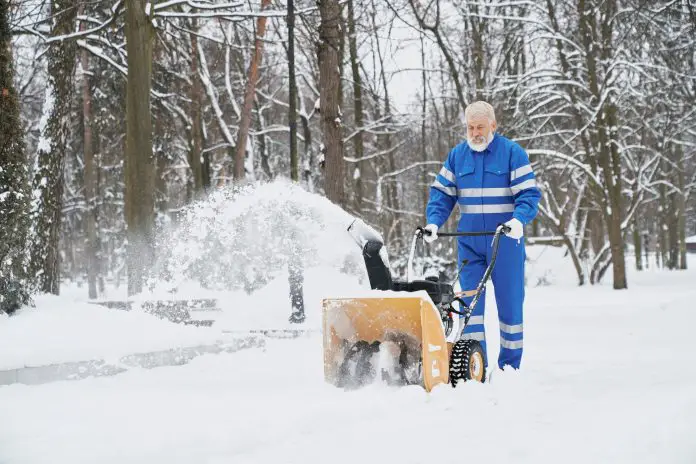 Man cleaning snow with snowblover