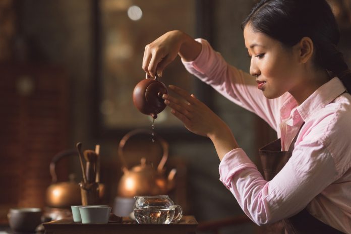 Young woman pouring tea