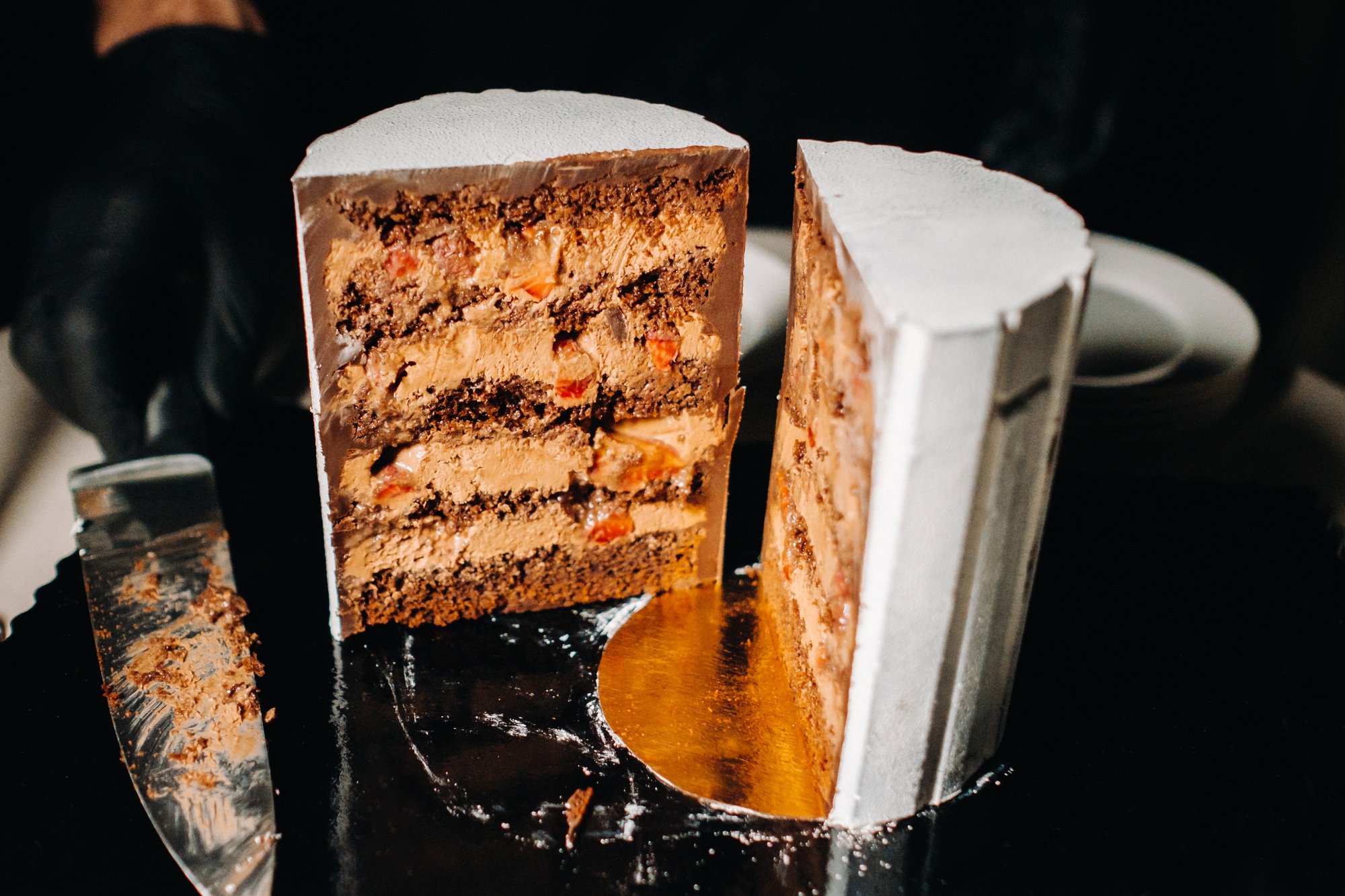 Amazing Cakes. Sliced chocolate wedding cake cake with amazing filling on a black background.Large