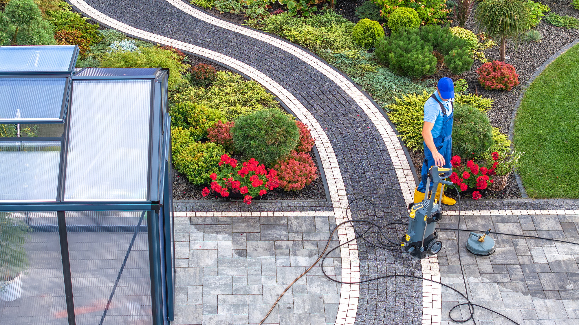 Man Cleaning His Backyard Garden Paths Using Pressure Washer