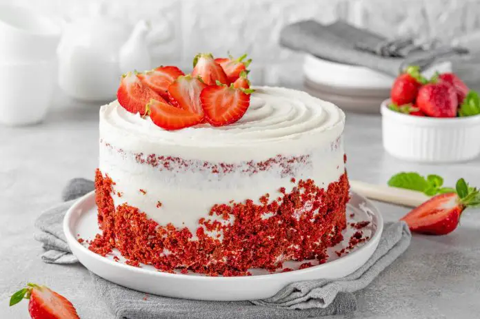 Red velvet cake with strawberries. Cake from red sponge cakes and cream cheese frosting,