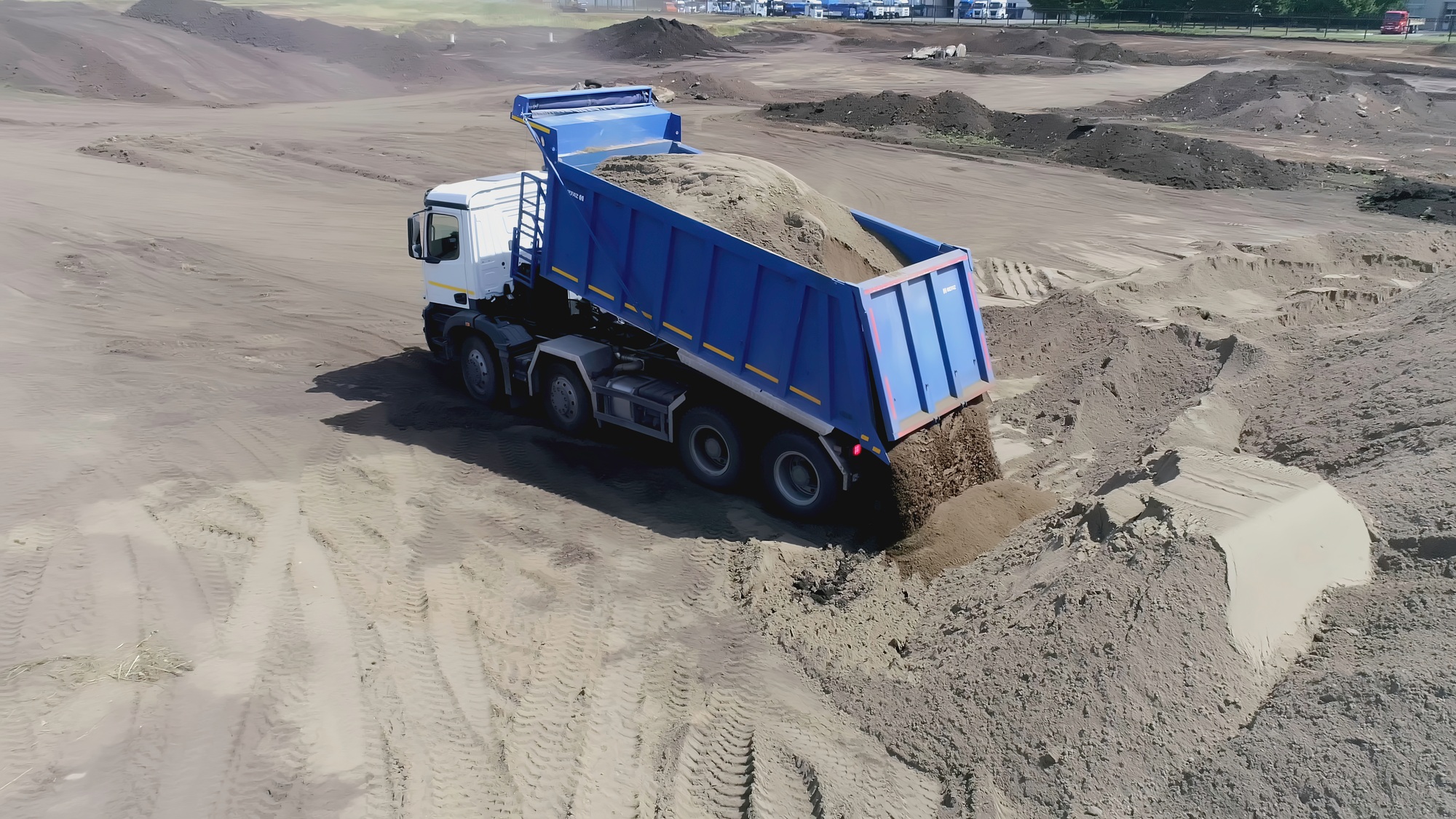 Top view of dump truck unloading sand. Scene. Dump truck dumps sand or earth on construction site