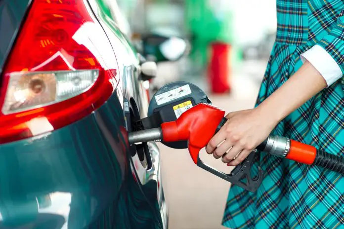 Woman fills petrol into the car at a gas station