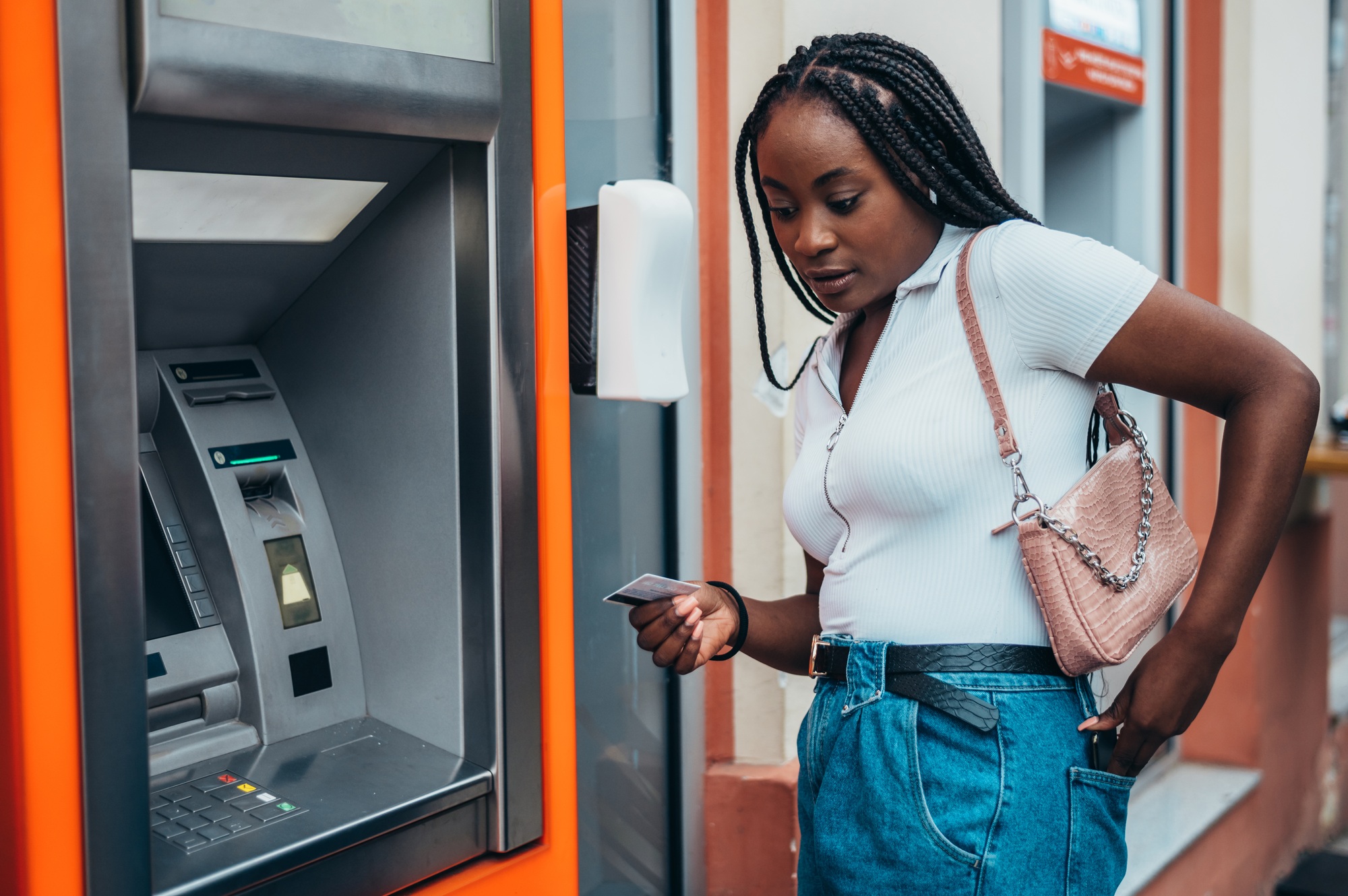 Beautiful african american woman using atm machine