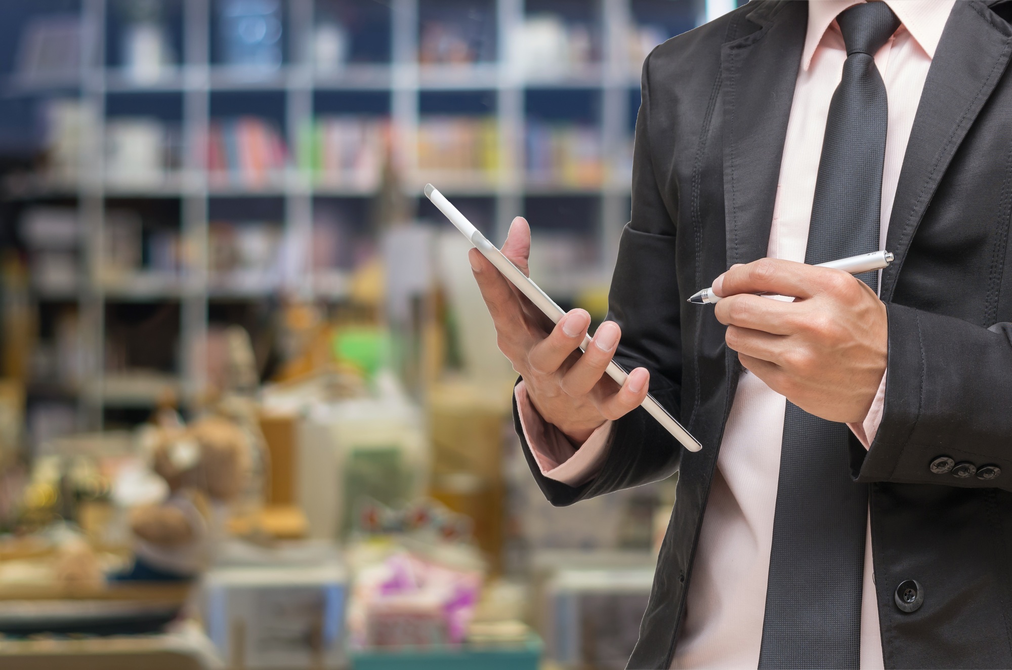 Businessman using the tablet on Abstract blurred photo of book store background