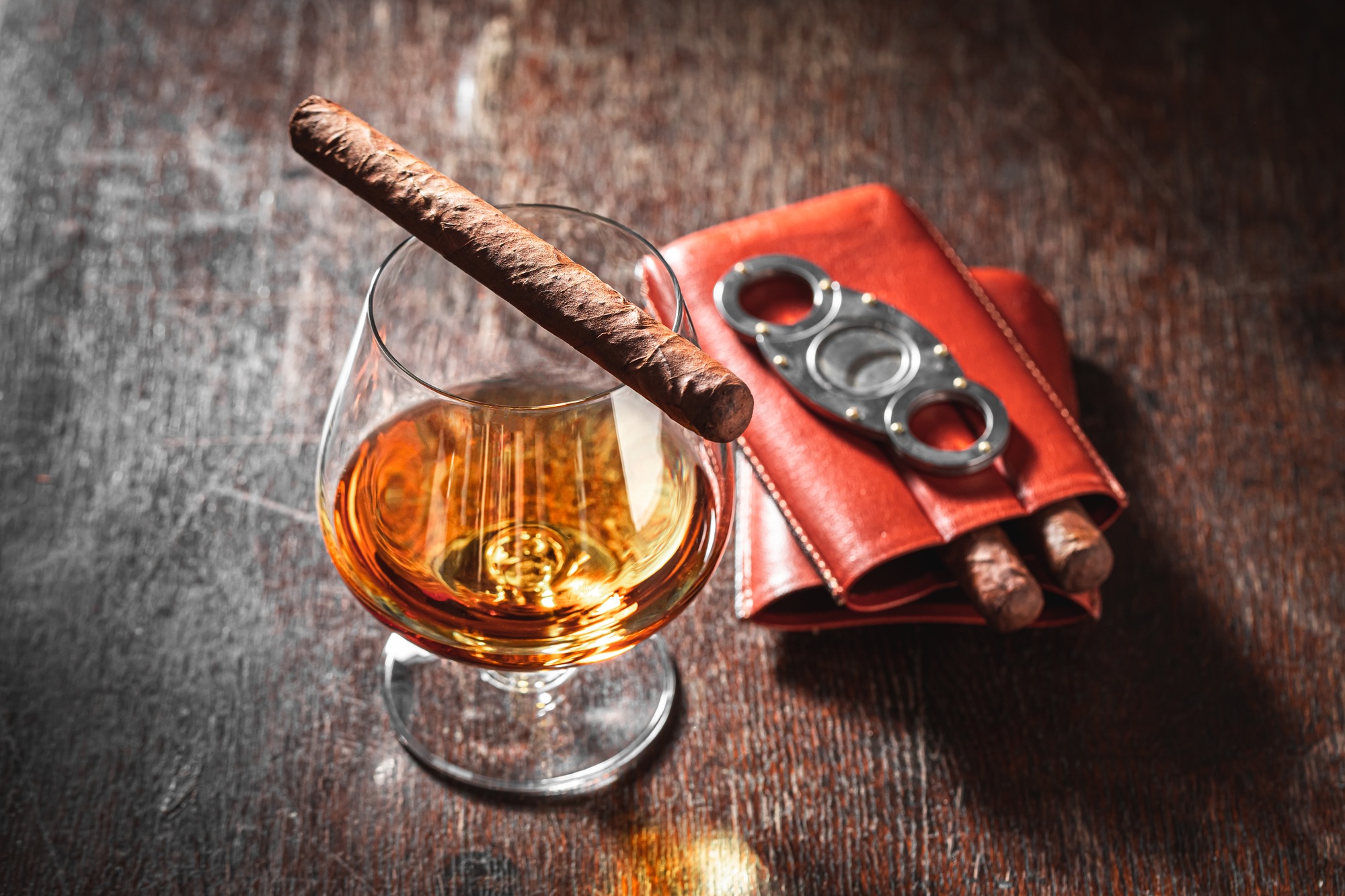 Cigar on brendy glass on wooden table