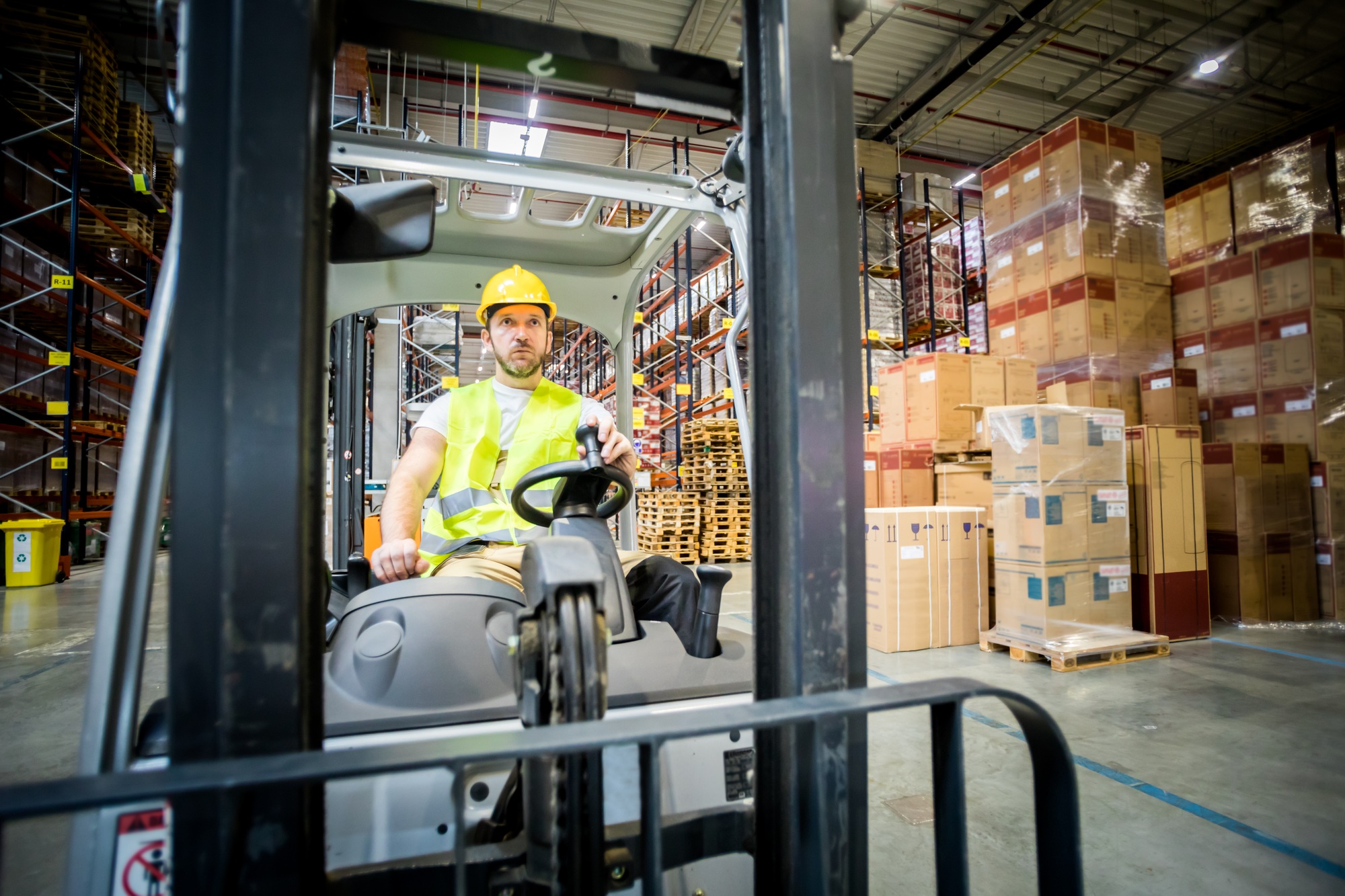 Forklift operator during work in large warehouse