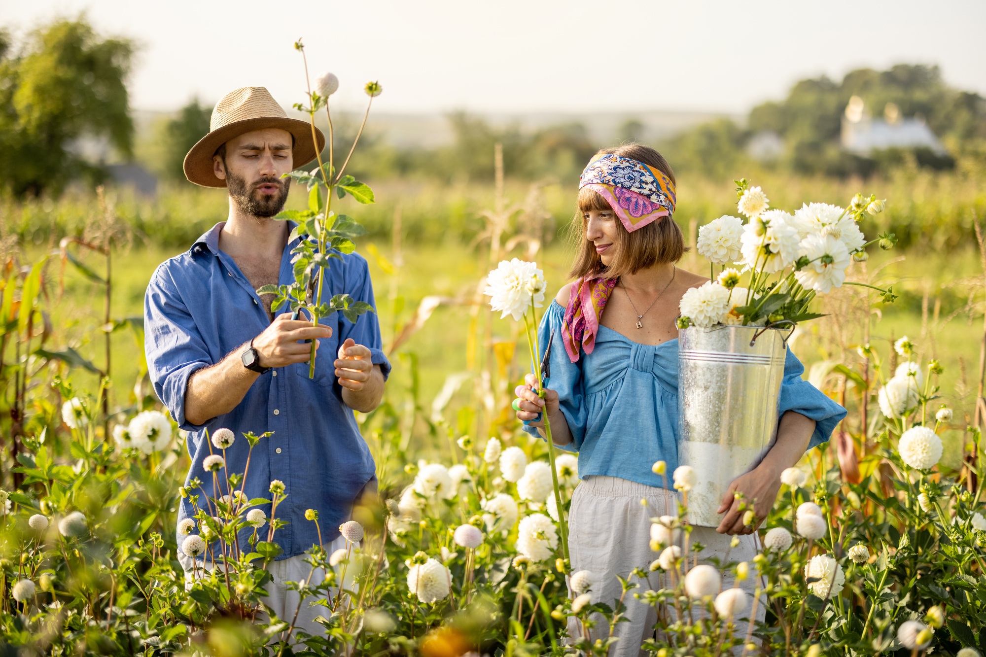 Man and woman pick up flowers at farm outdoors