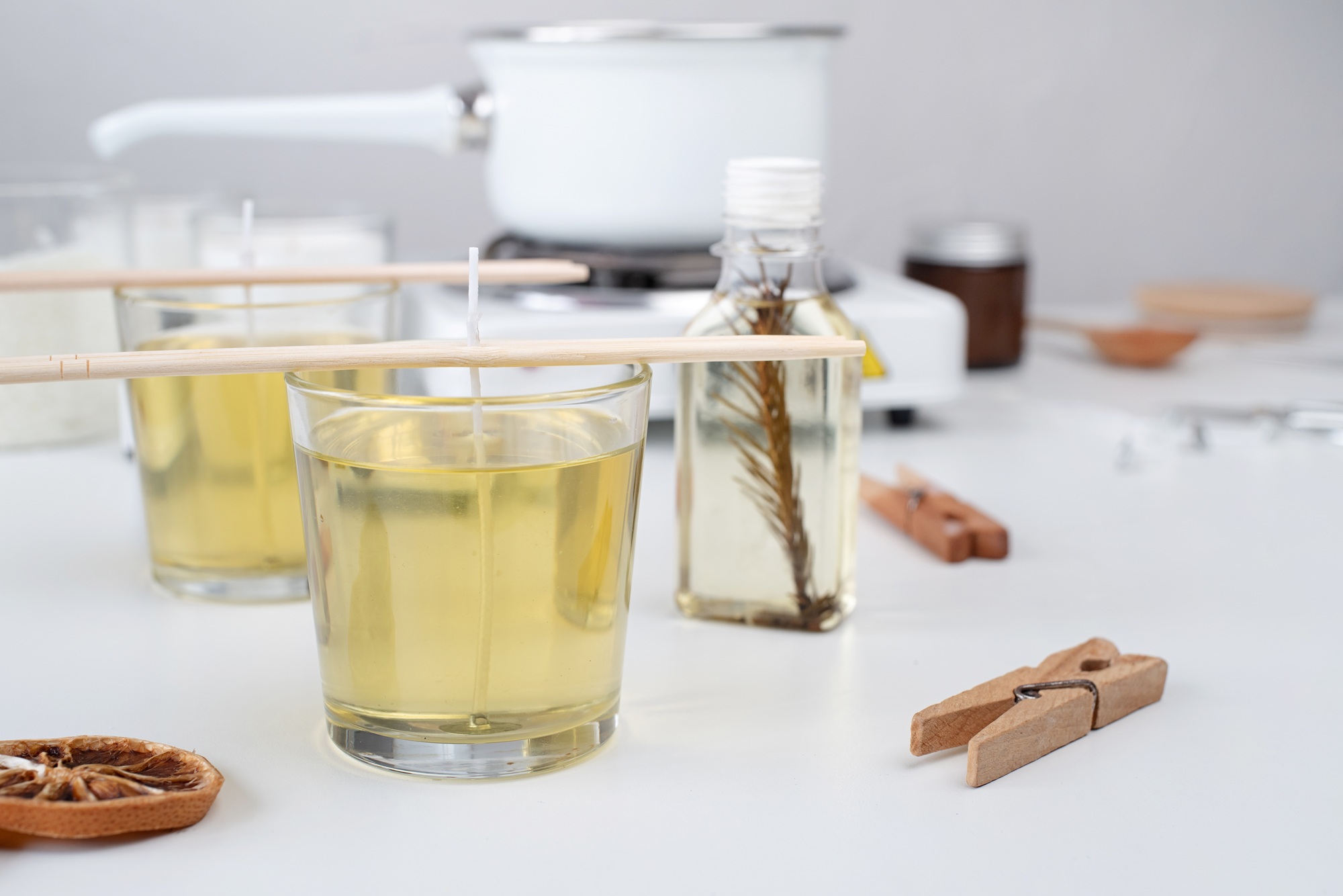 woman making candles, poring melted soy wax to the candle jar