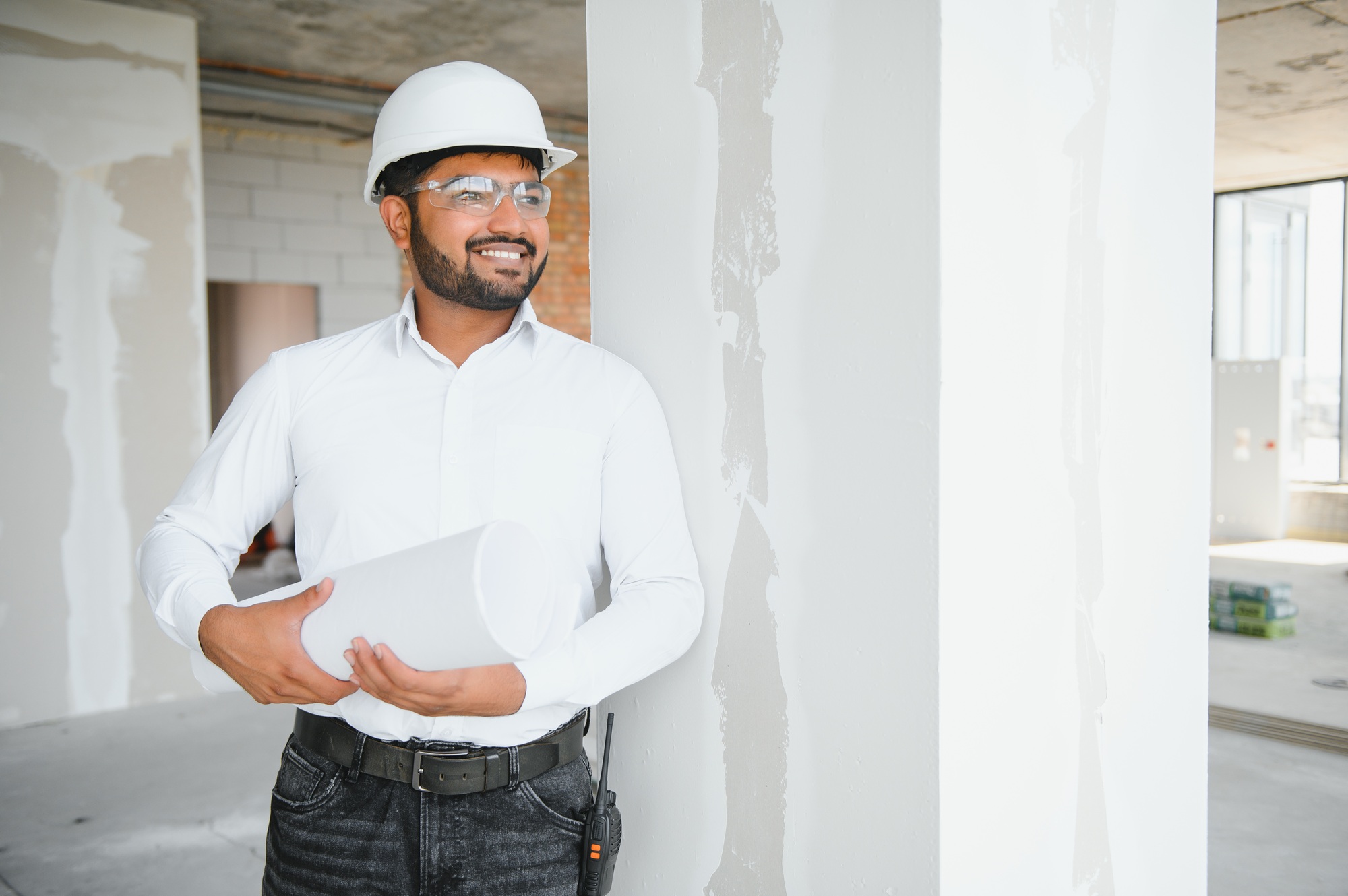 Asian Engineer standing on site construction posting confident