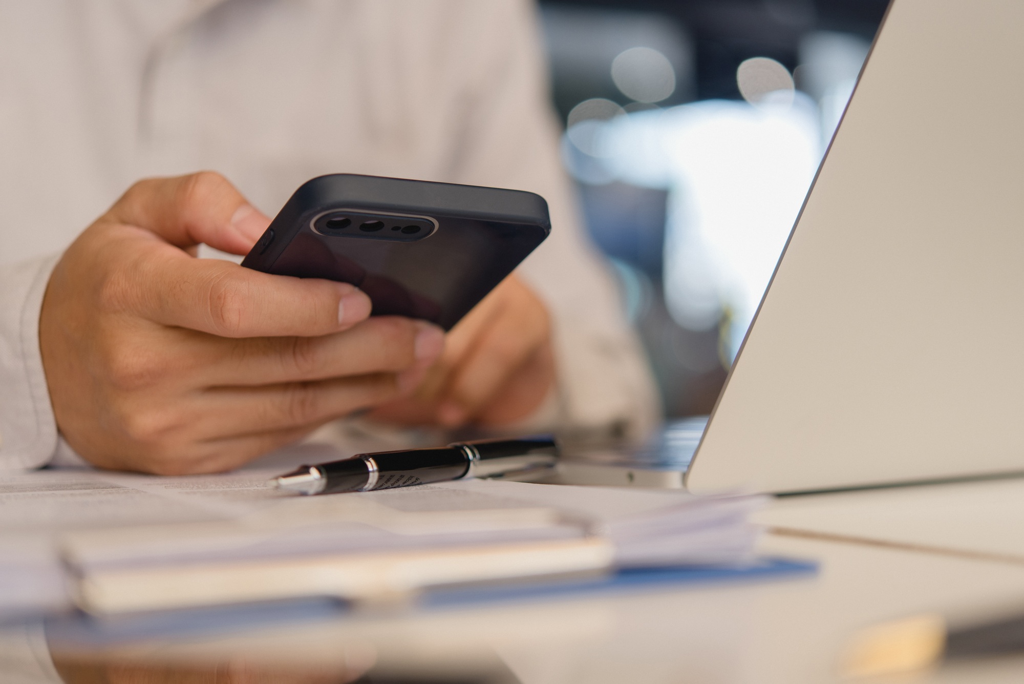 businessperson holding a mobile smartphone. work-related activity checking emails, messaging clients