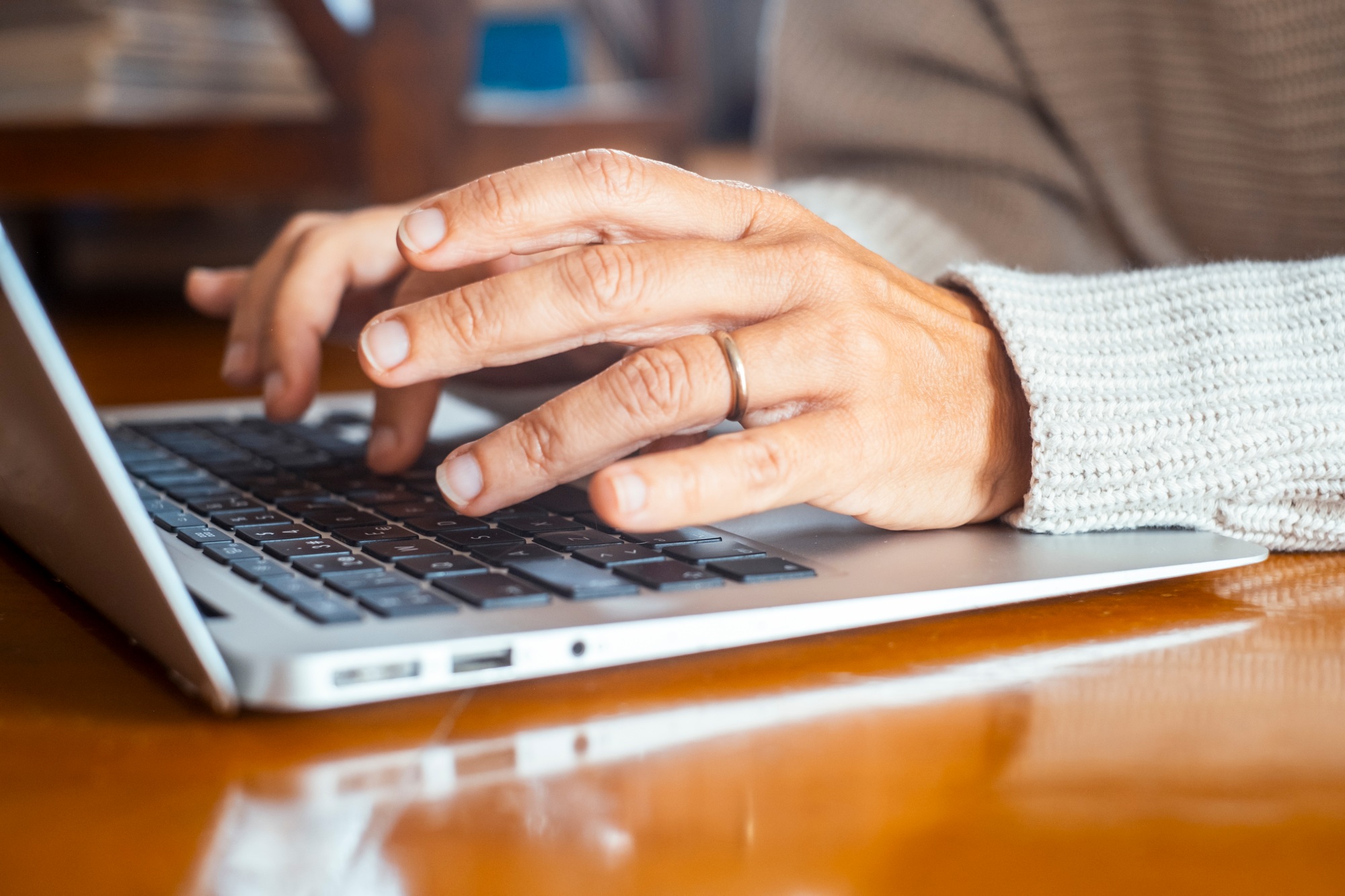 Close up of woman hands writing on keyboard laptop email or searching the net. People and online