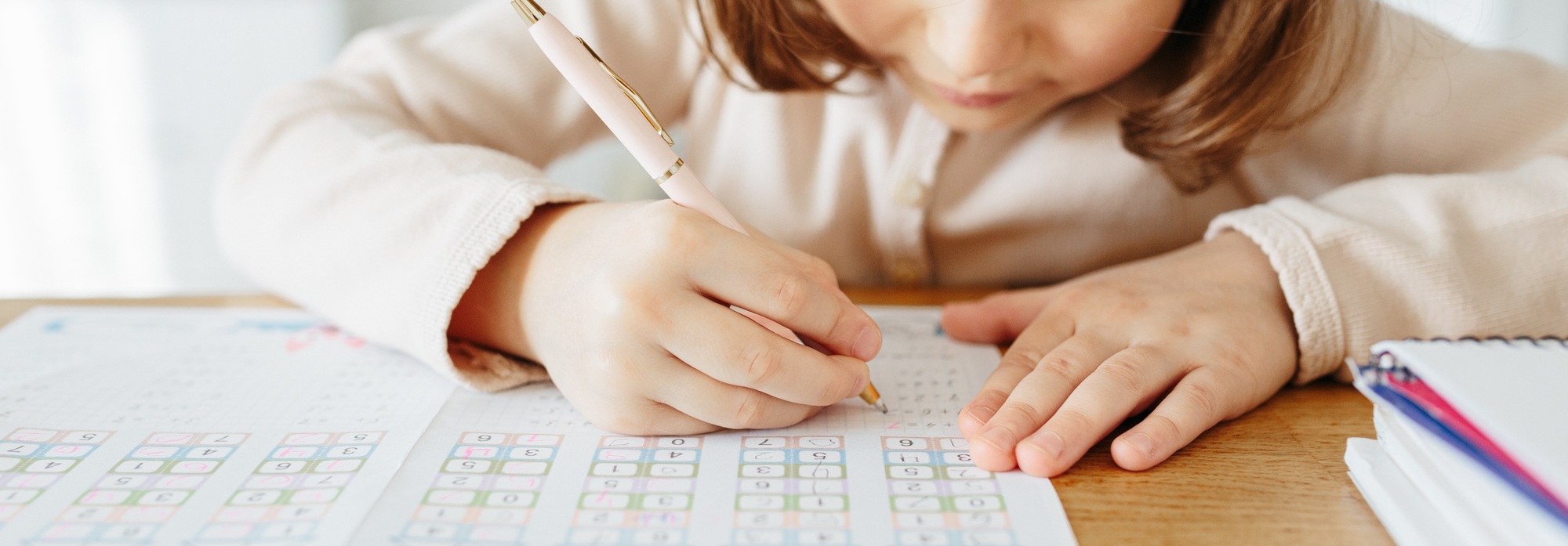 Cute preschooler girl writing maths, learning home. photo banner for website header design