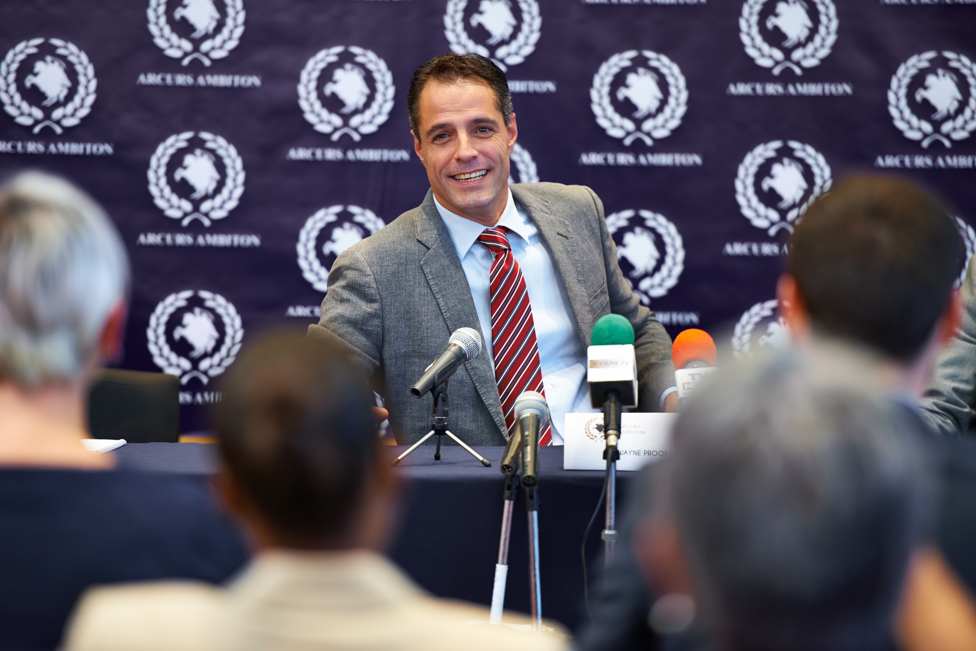 Easing their concerns. Shot of a group of businesspeople in a press conference.