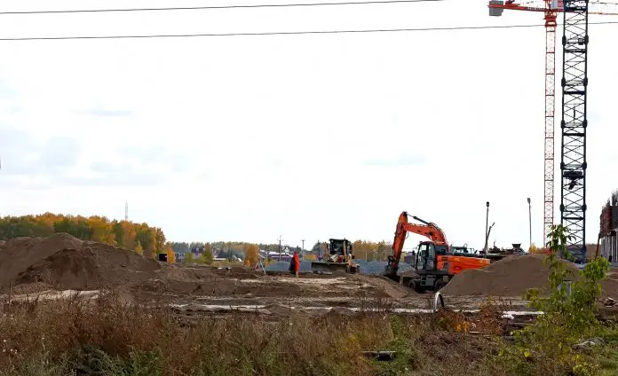 Excavator dig trench on sunset background. Backgoe on earthwork. Construction natural gas pipeline.