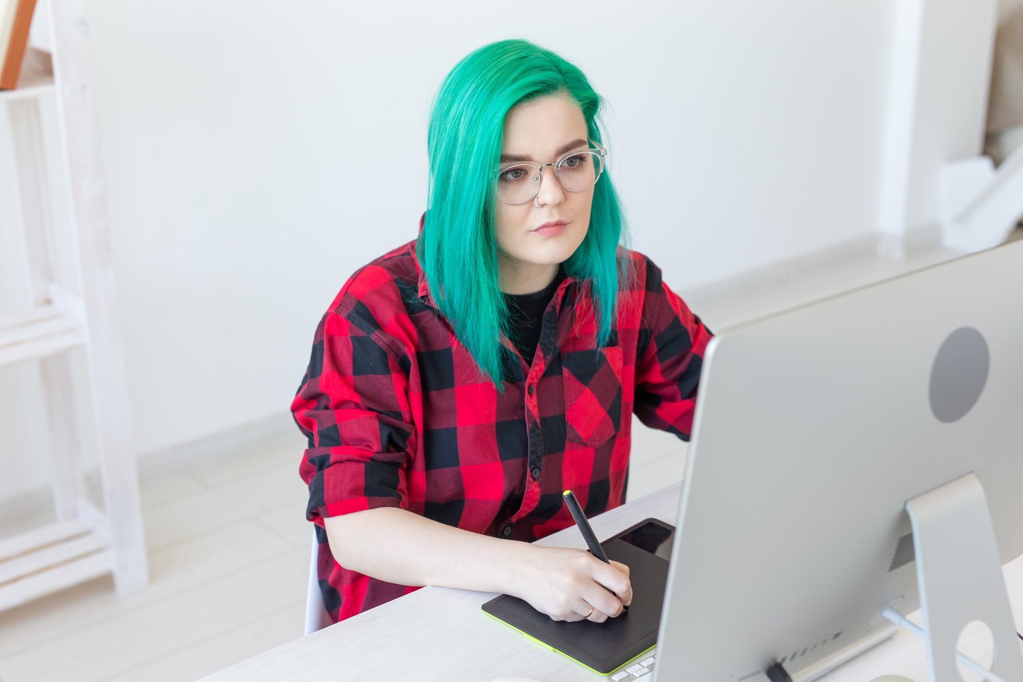 Graphic designer, people concept - Young designer female hipster with graphic tablet working in