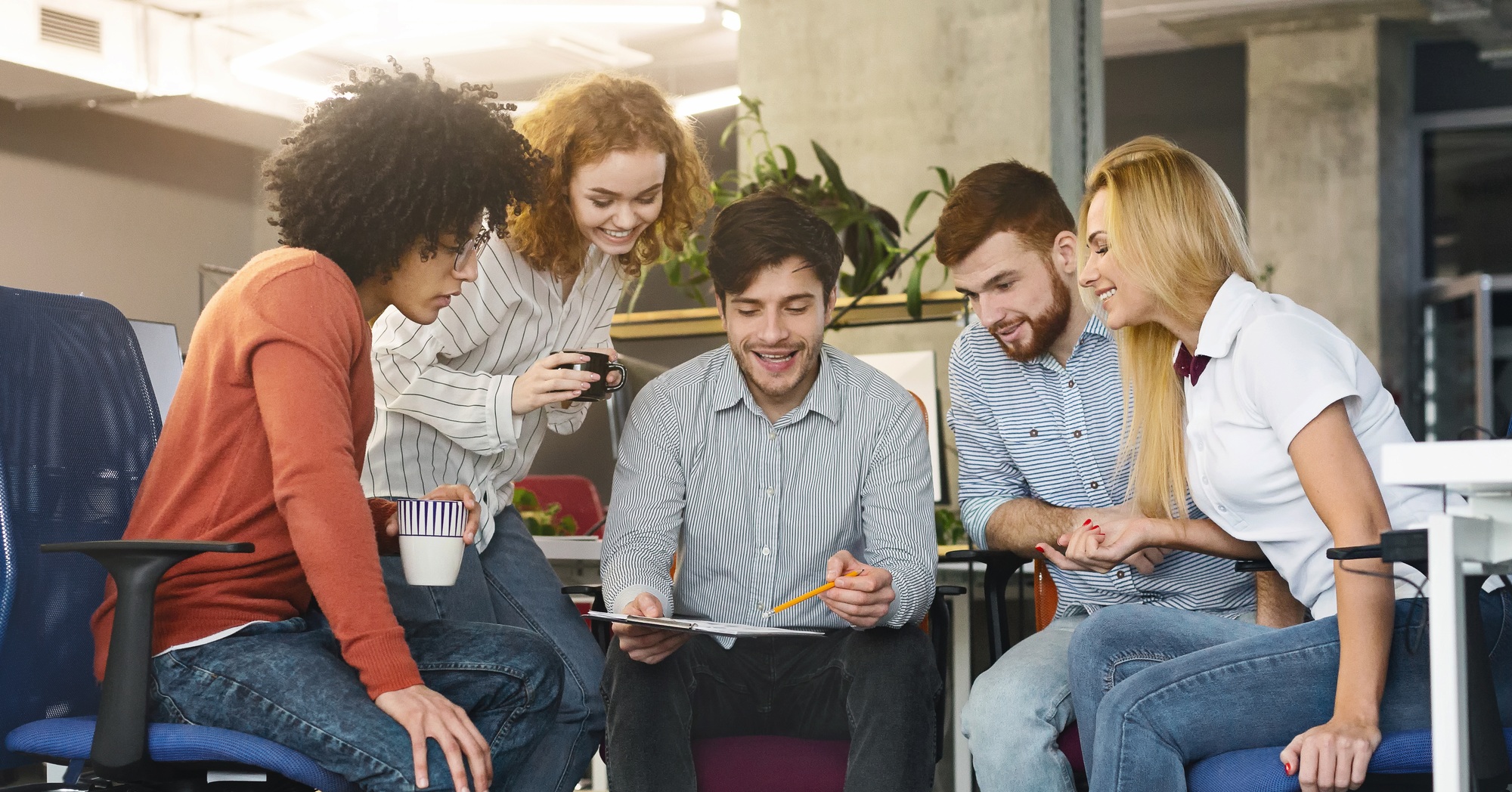 Group of young coworkers discussing new marketing strategy in office