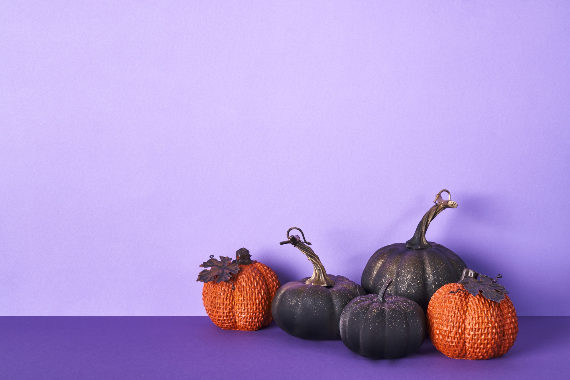 Halloween composition with pumpkins on violet background. Greeting card template, Halloween decor