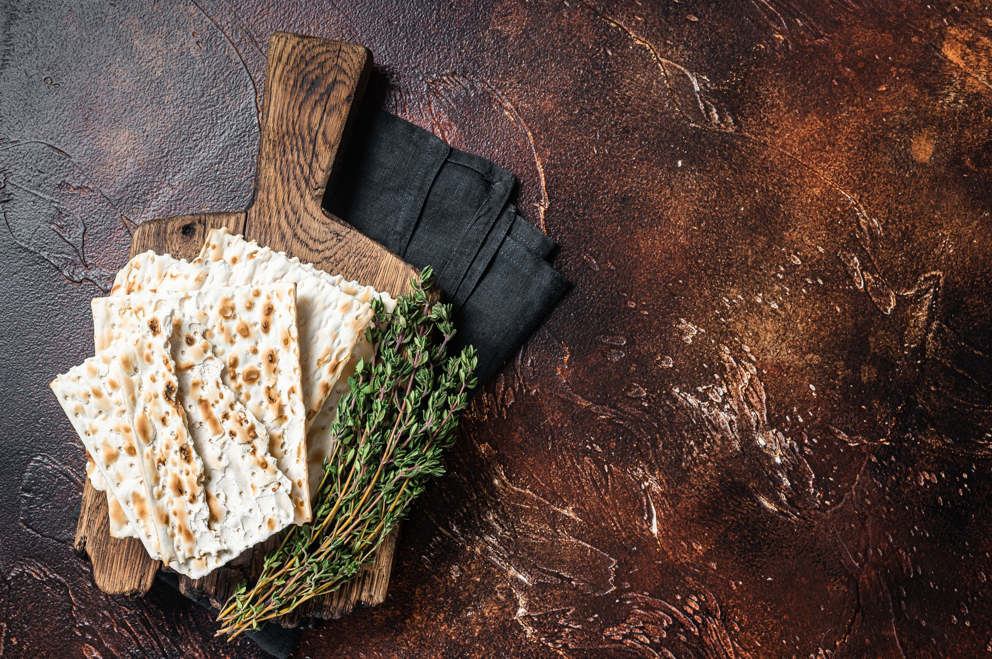 Happy Passover concept, matzah on a wooden board. Dark background. Top view. Copy space