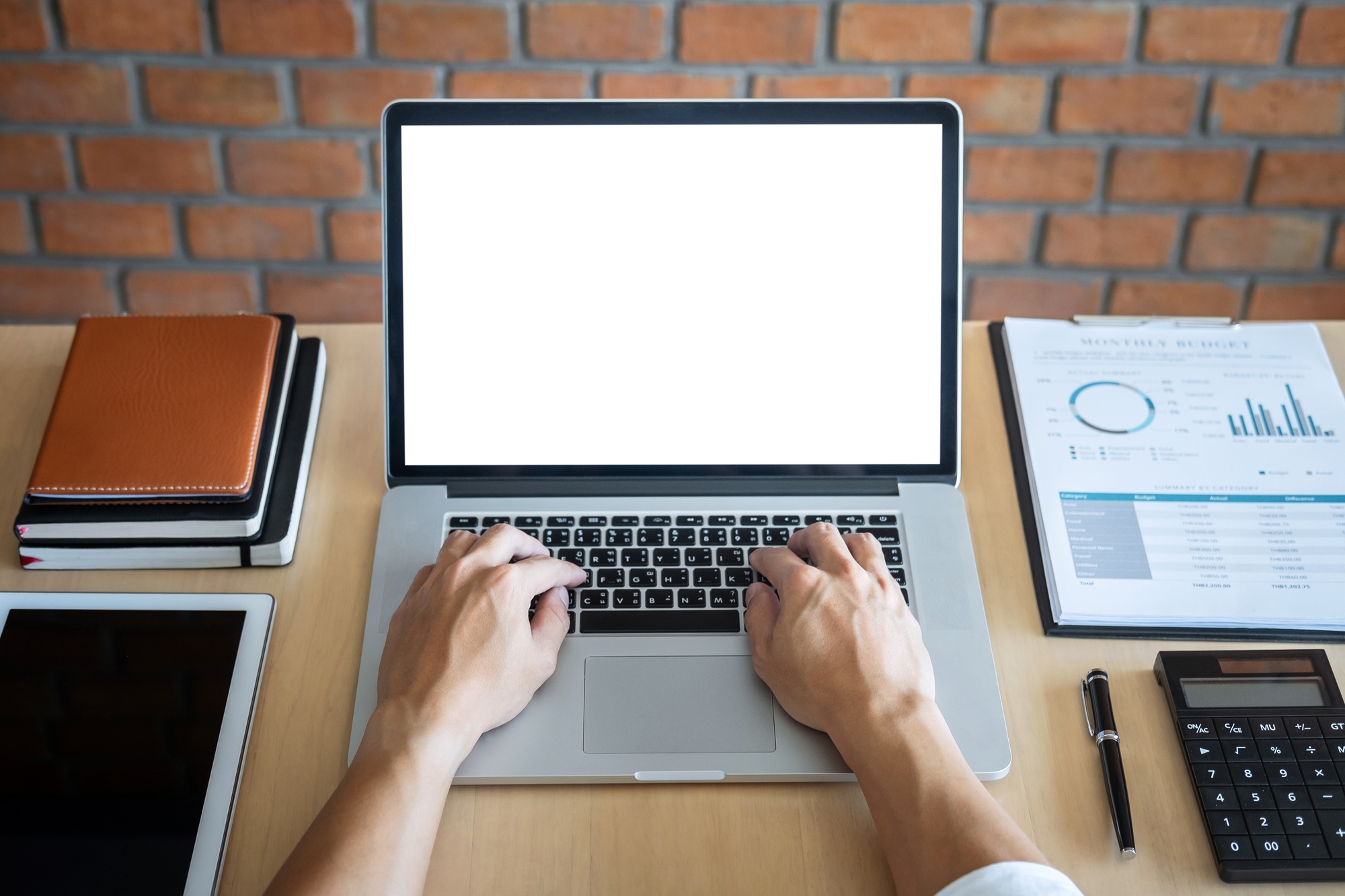 Image of Young man working in front of the laptop looking at screen with a clean white screen and