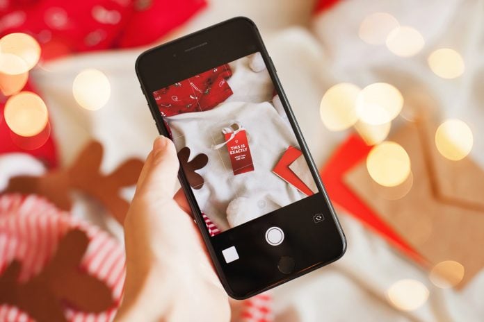 Influencer making christmas content on mobile phone for social media fro winter holiday season topic