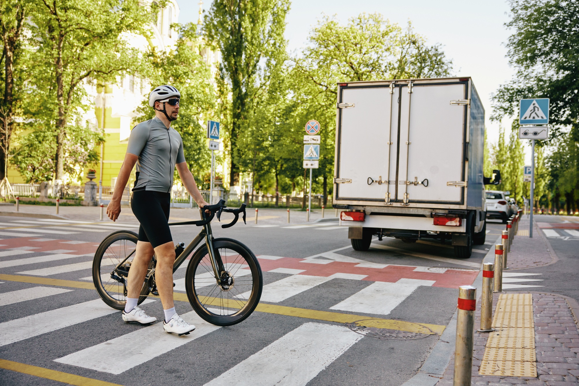 Man cyclist crossing city road using pedestrian in compliance with traffic rules