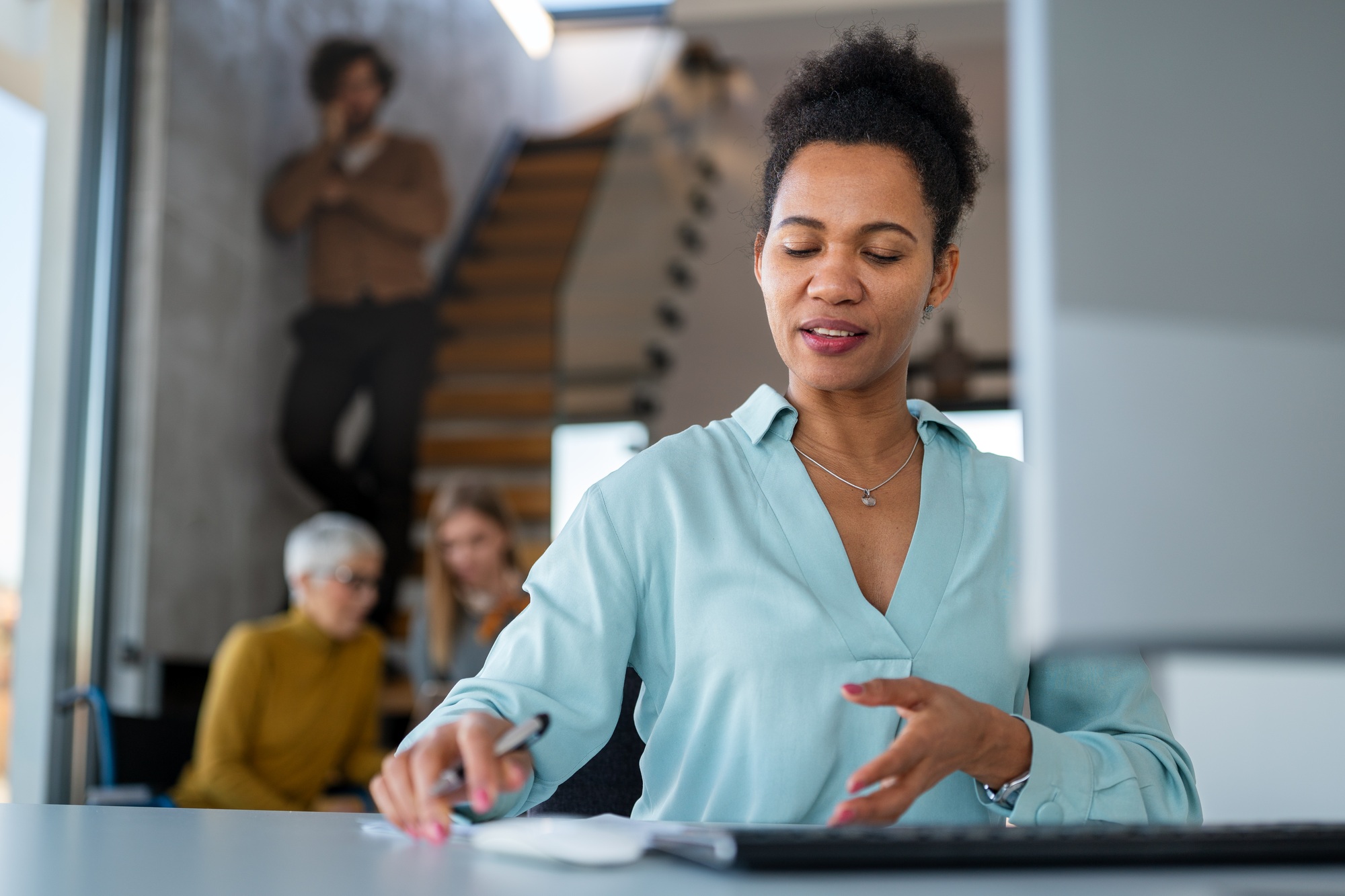 Manager woman sitting at a desk in creative office working on computer in marketing agency.