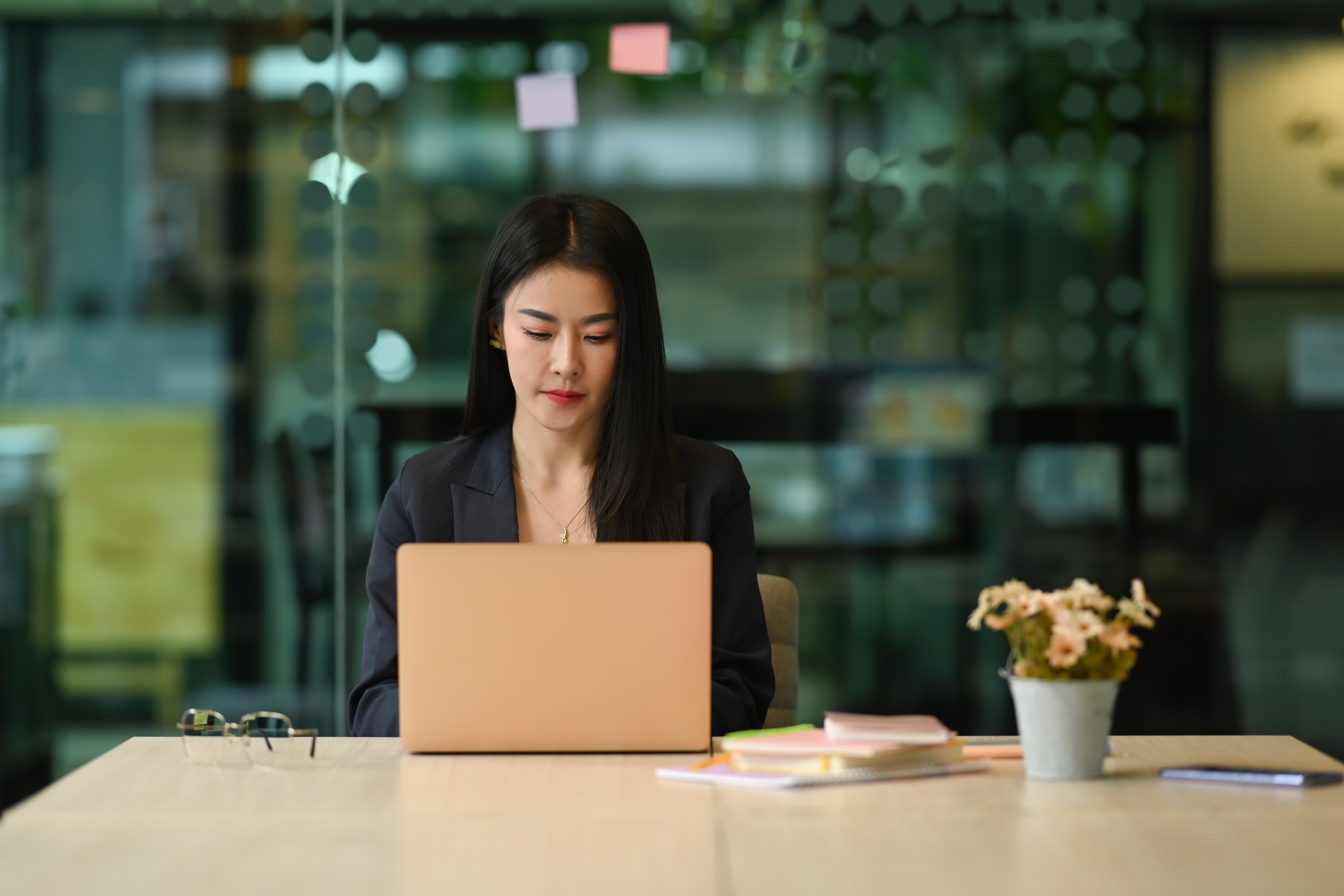 Millennial female entrepreneur typing business email, working online on her laptop computer.