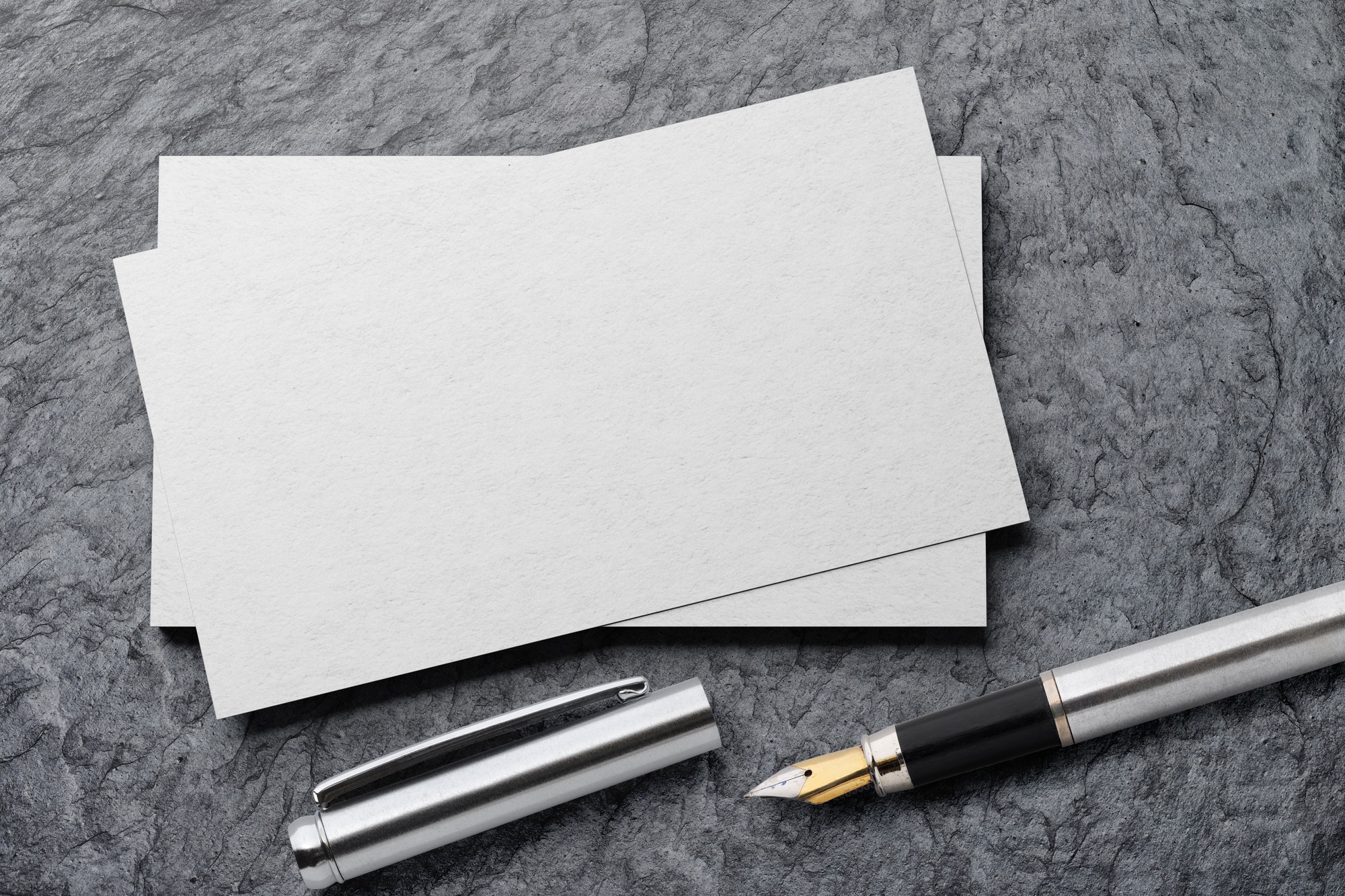 Mockup of business card with fountain pen at black slate background