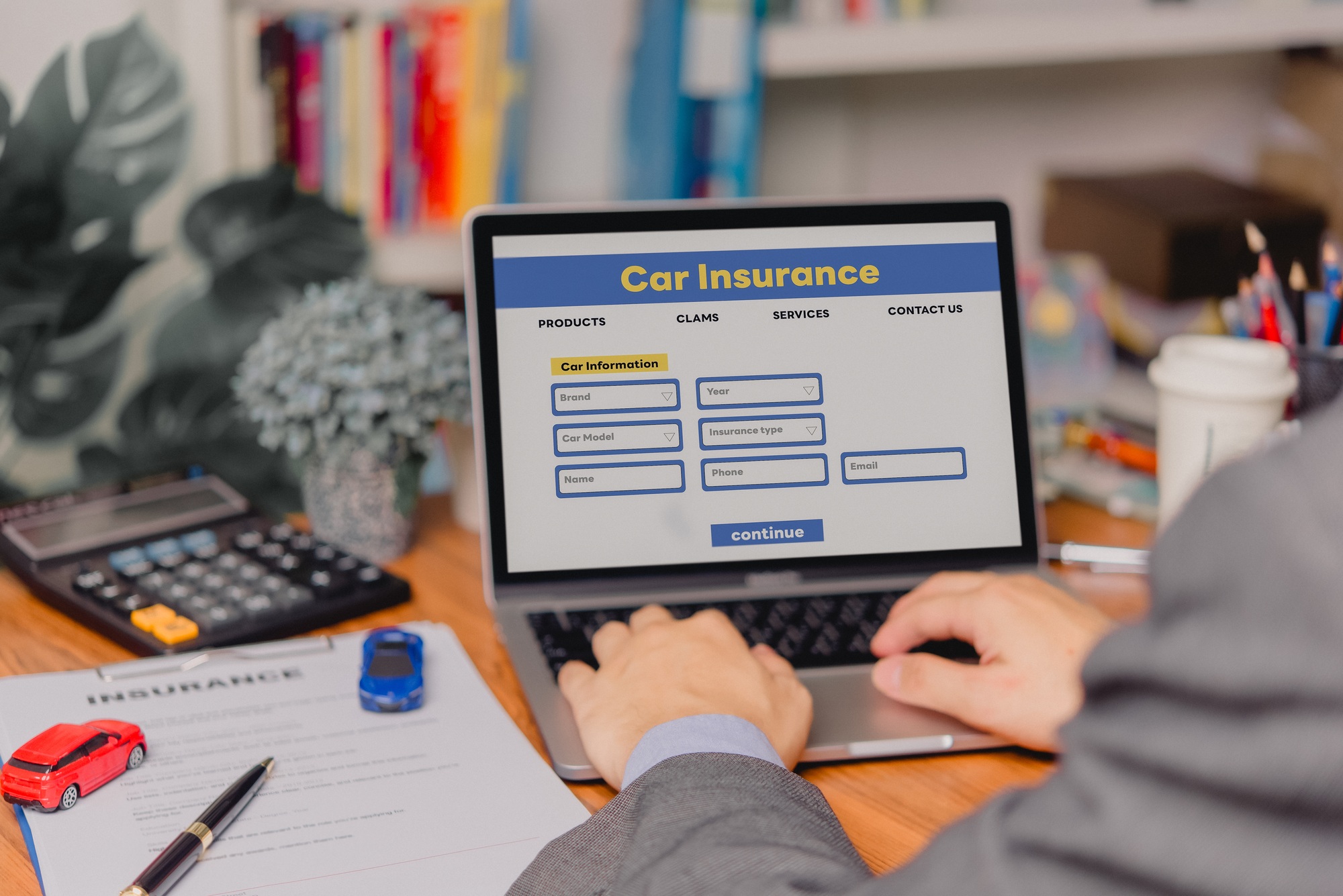 person using a laptop device to access an online car insurance platform customers can compare quotes