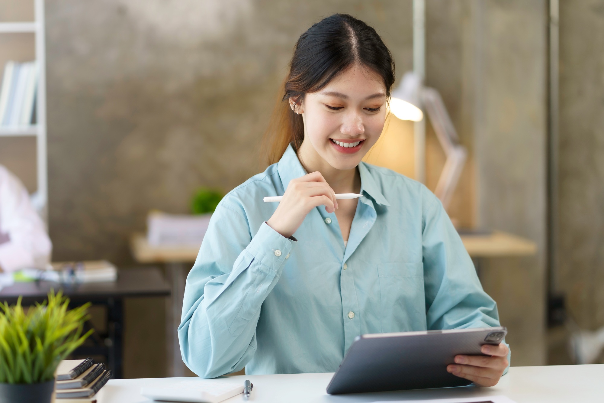 Portrait of young Asian business woman using digital tablet in the office.