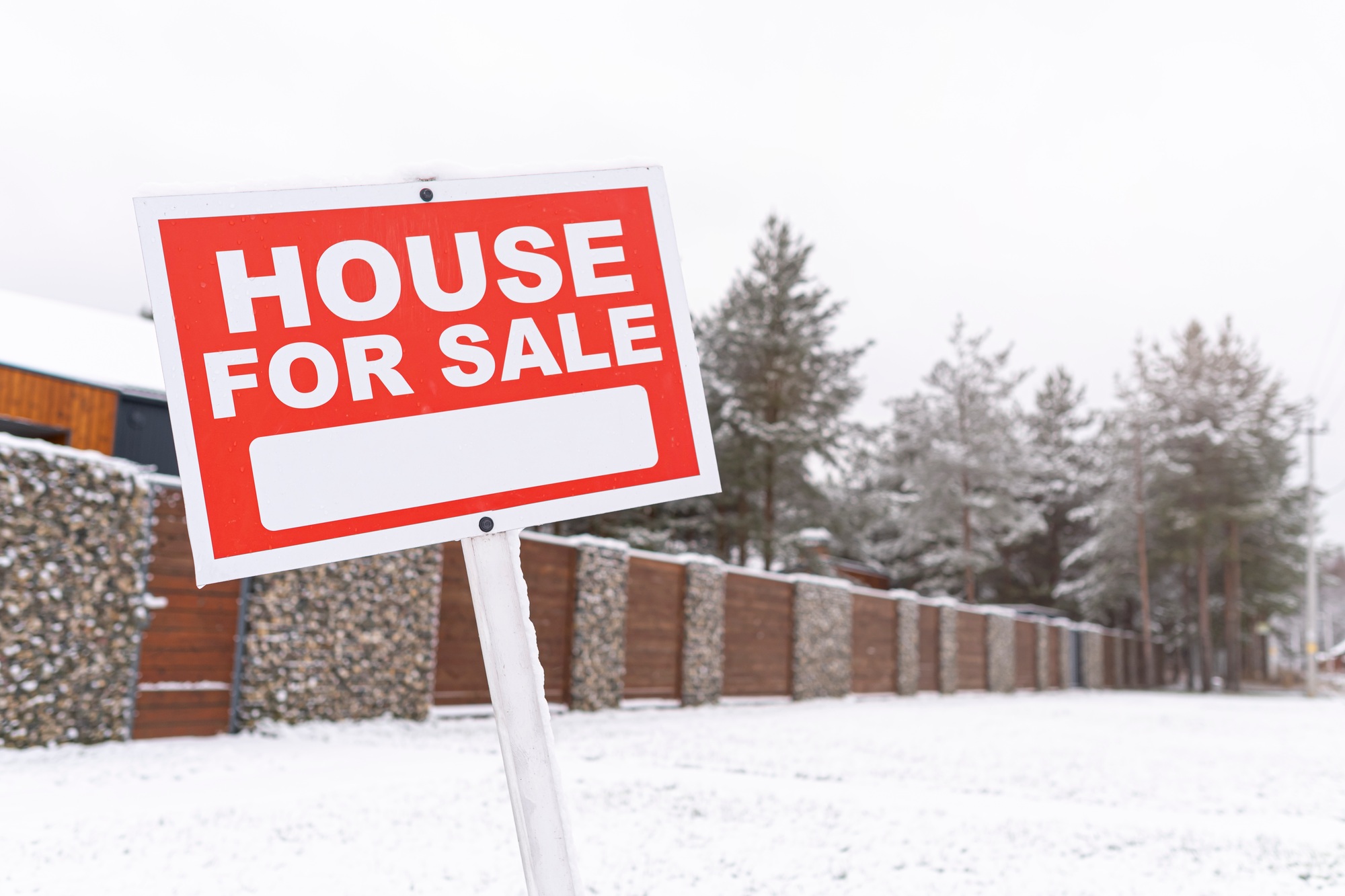 Red sign - house for sale, outdoors in winter. Buying suburban real estate