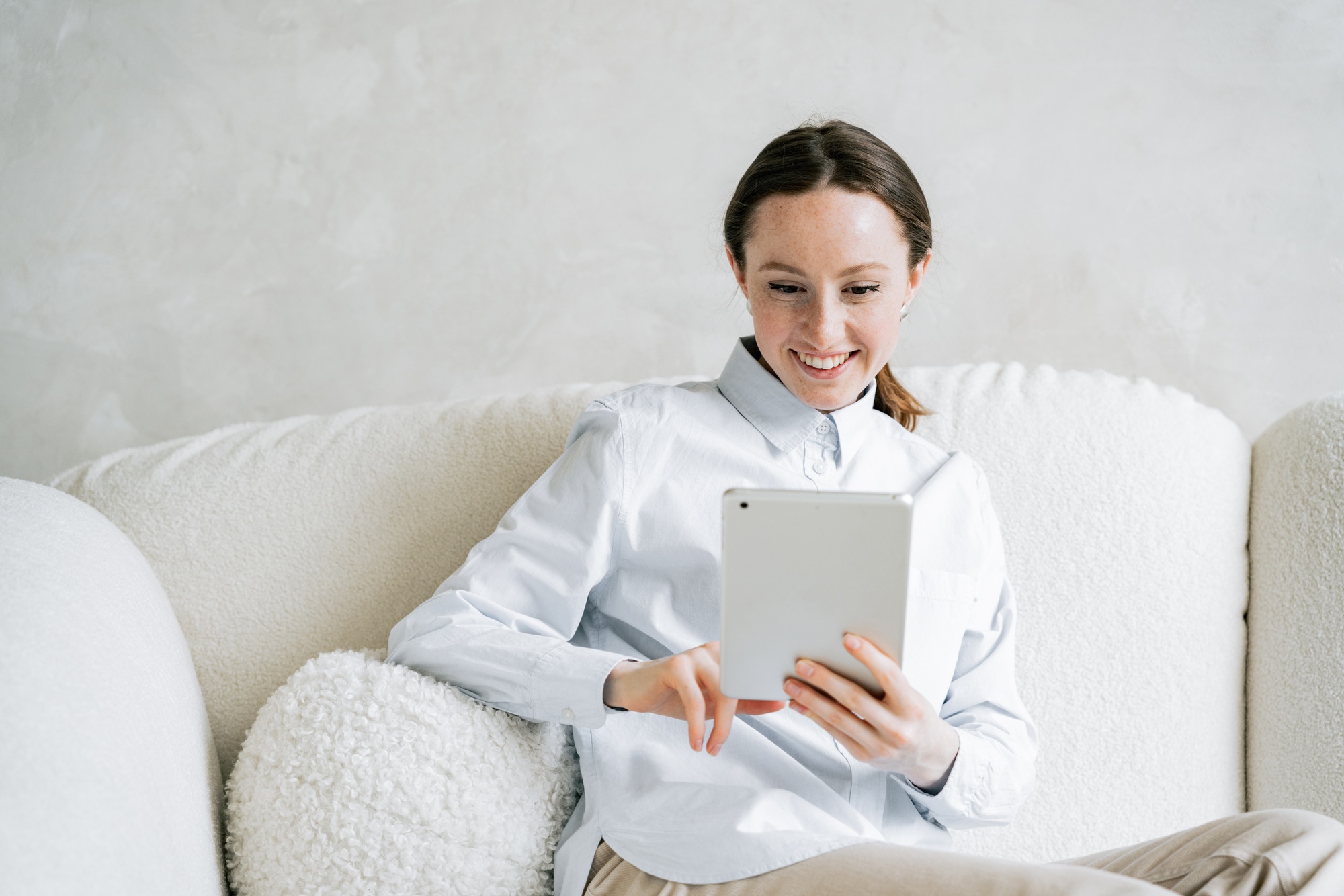 Use a PC and tablet workplace in a new bright office. Female influencer student