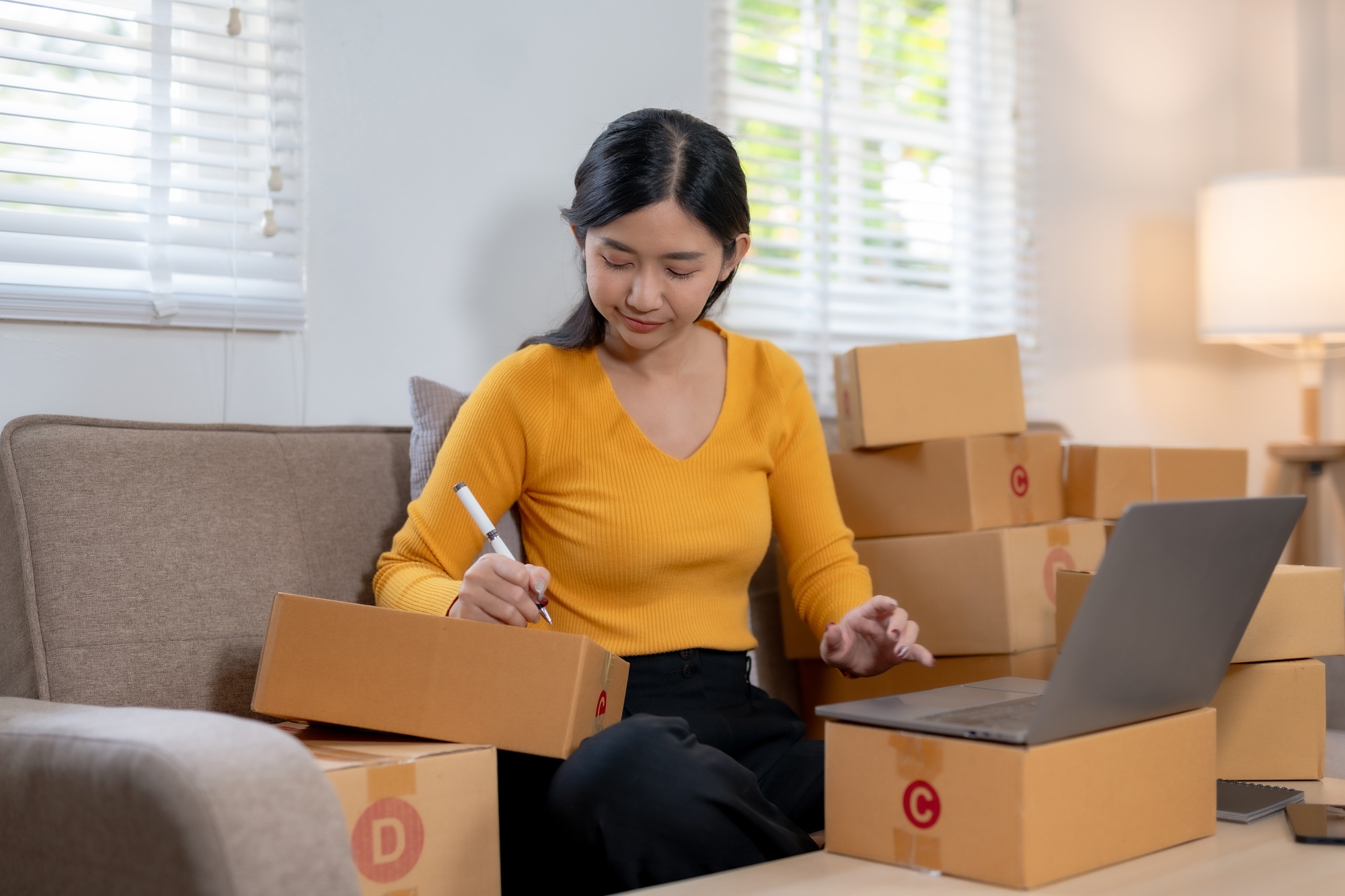 Woman preparing parcels for shipment in a home office setup