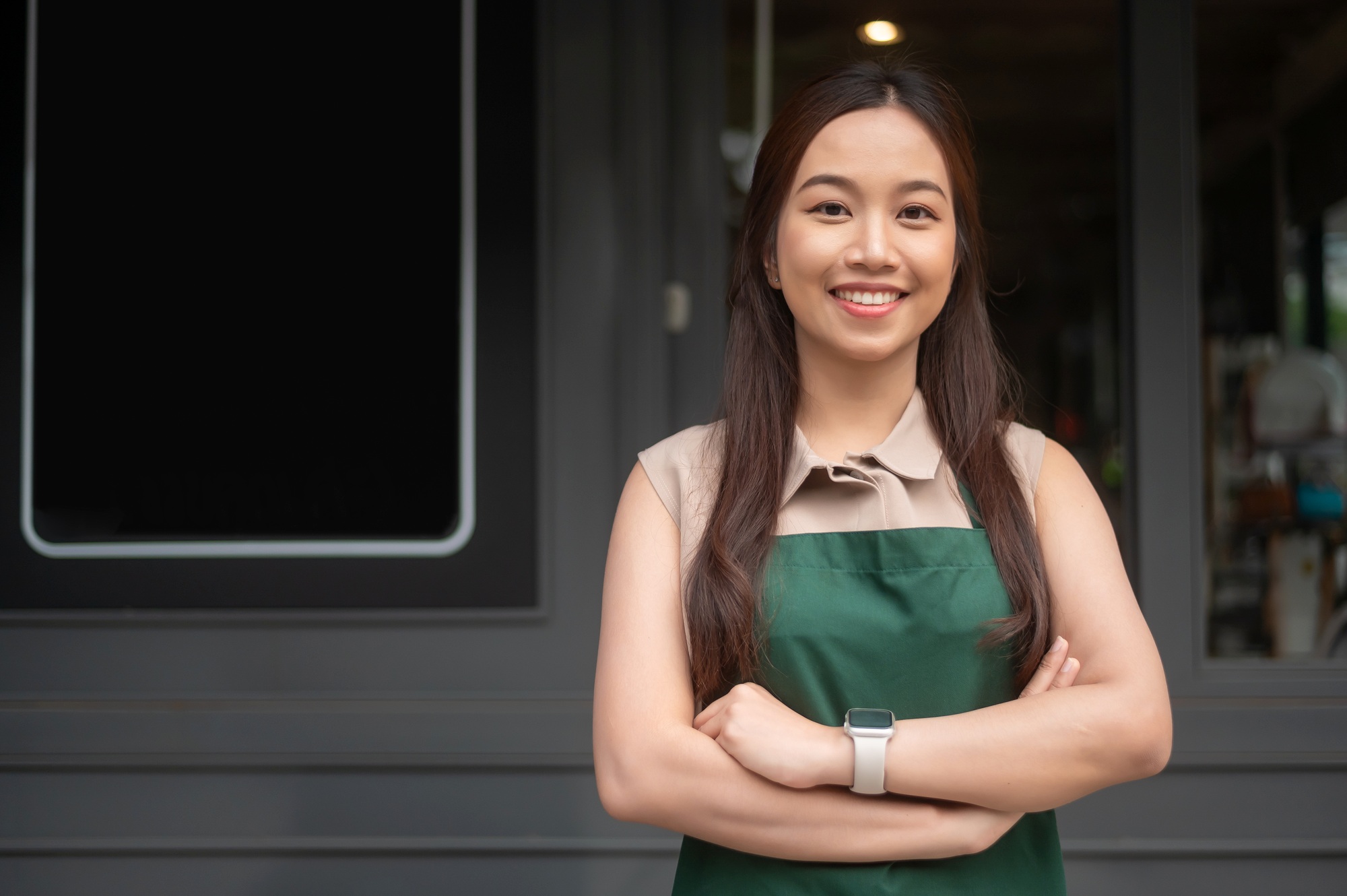 Young Asian woman cafe owner entrepreneur smiling in coffee shop, small business concept