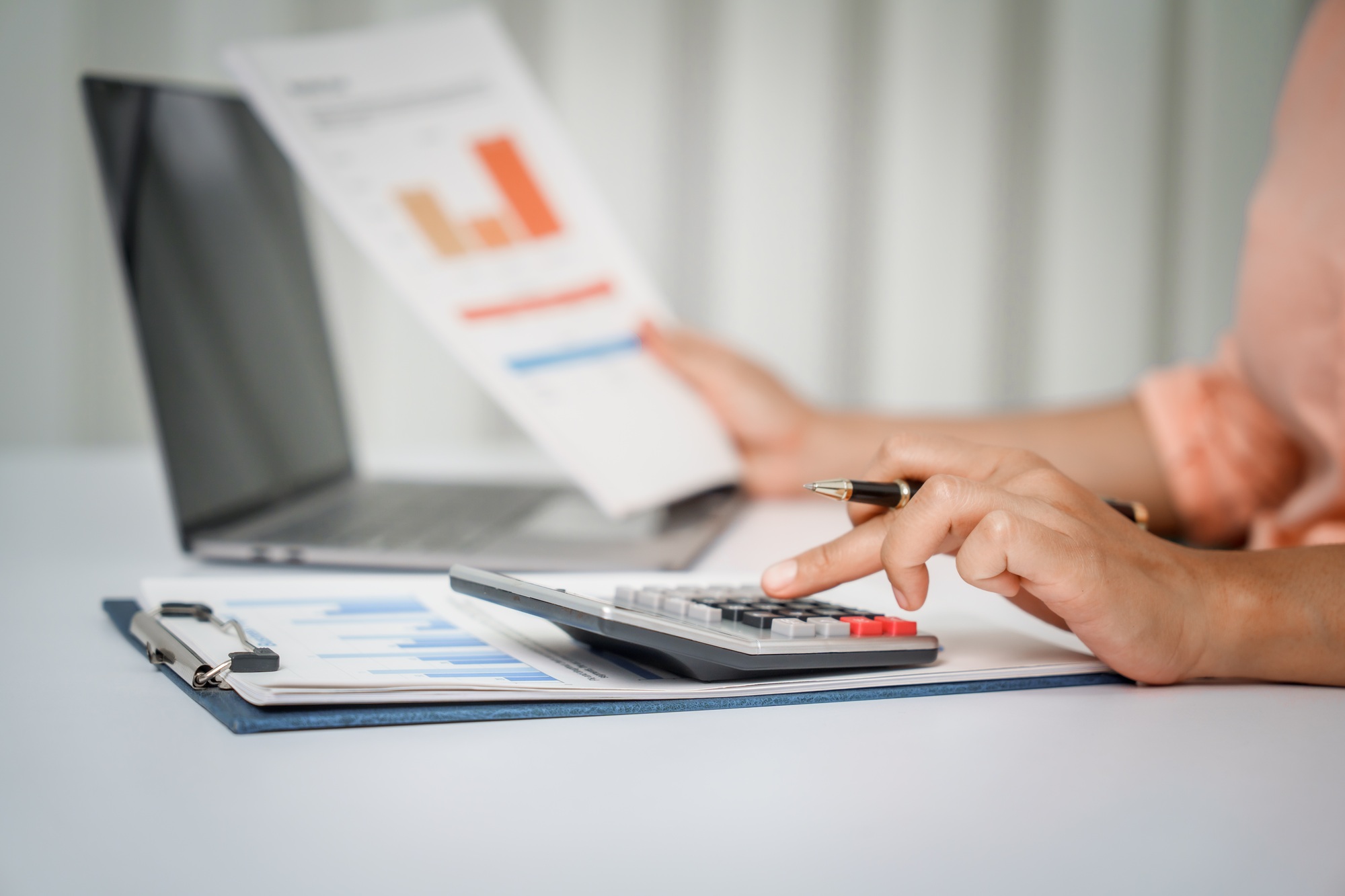 A close-up of a businesswoman working on a laptop in an office. As an accountant,records financial