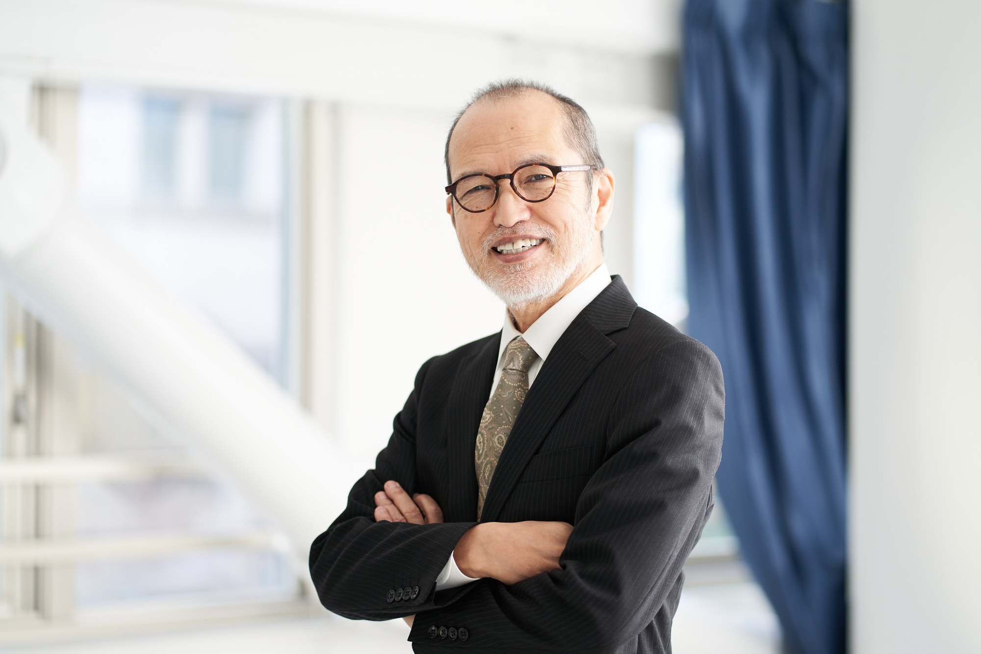 A man in a managerial position at a construction company with his arms folded