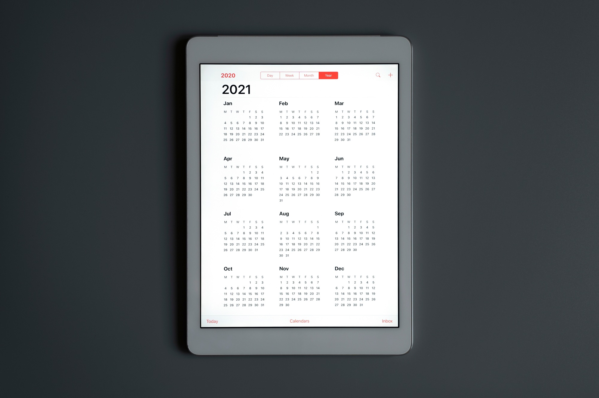 a tablet with an open calendar for 2021 year on a dark gray background