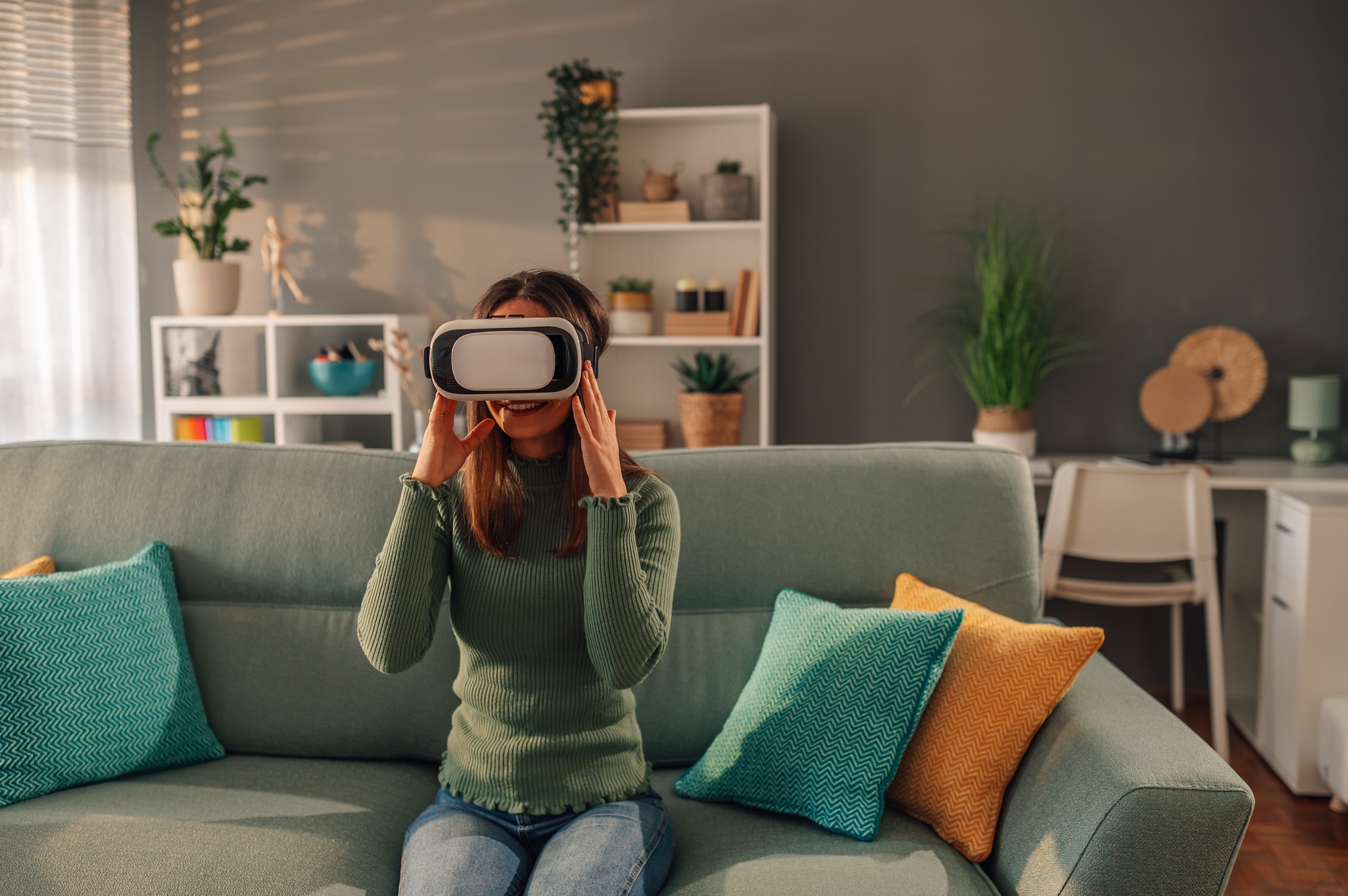 A woman is using virtual reality headset at home.
