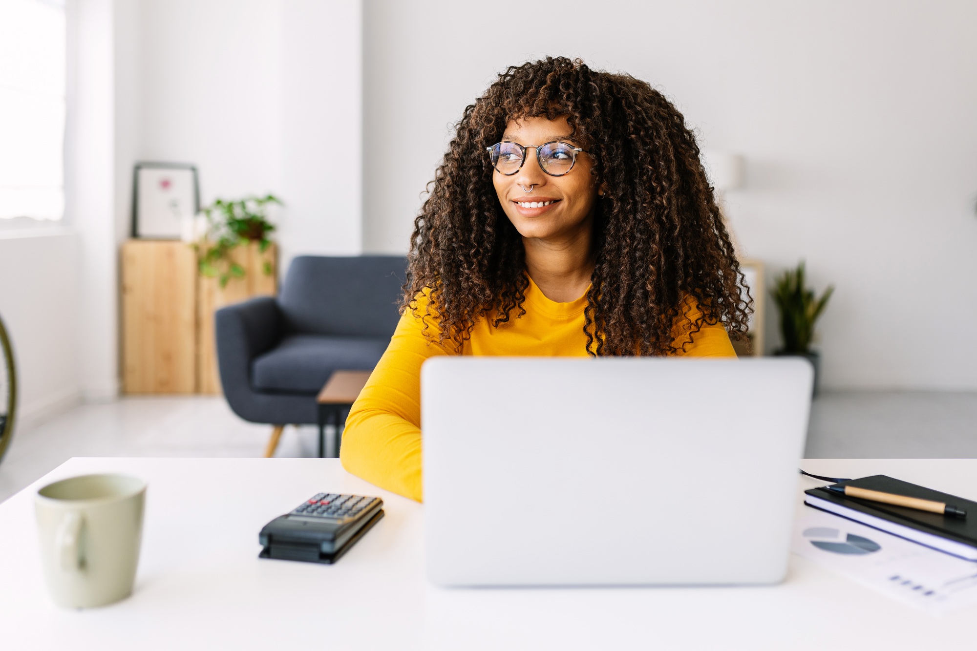 African american freelance woman working on laptop sitting on table at home