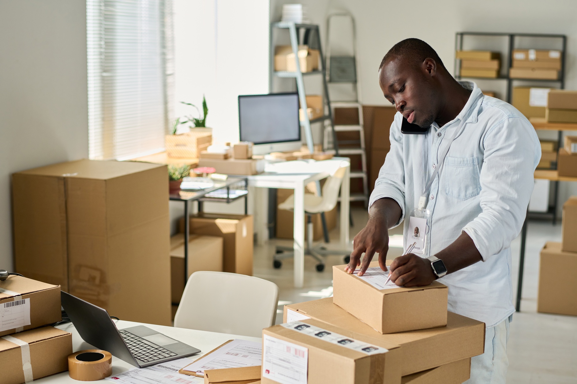 African American manager of marketplace filling in personal data of customer