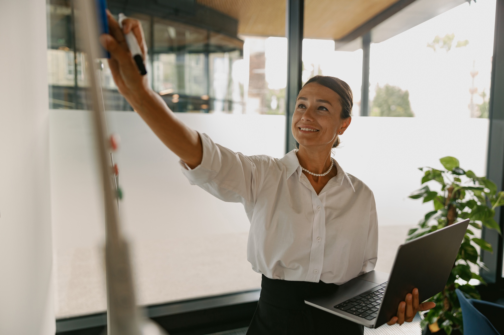 An Empowered Businesswoman is Actively Presenting Her Innovative Ideas in a Modern Office Space