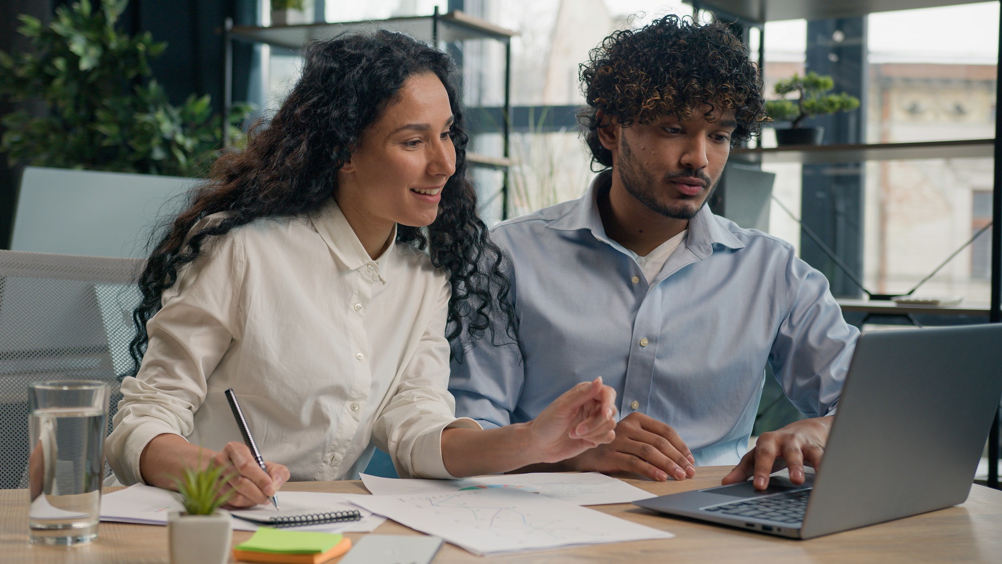 Arabian female employer insurance agent consult Indian male client discuss business project finance