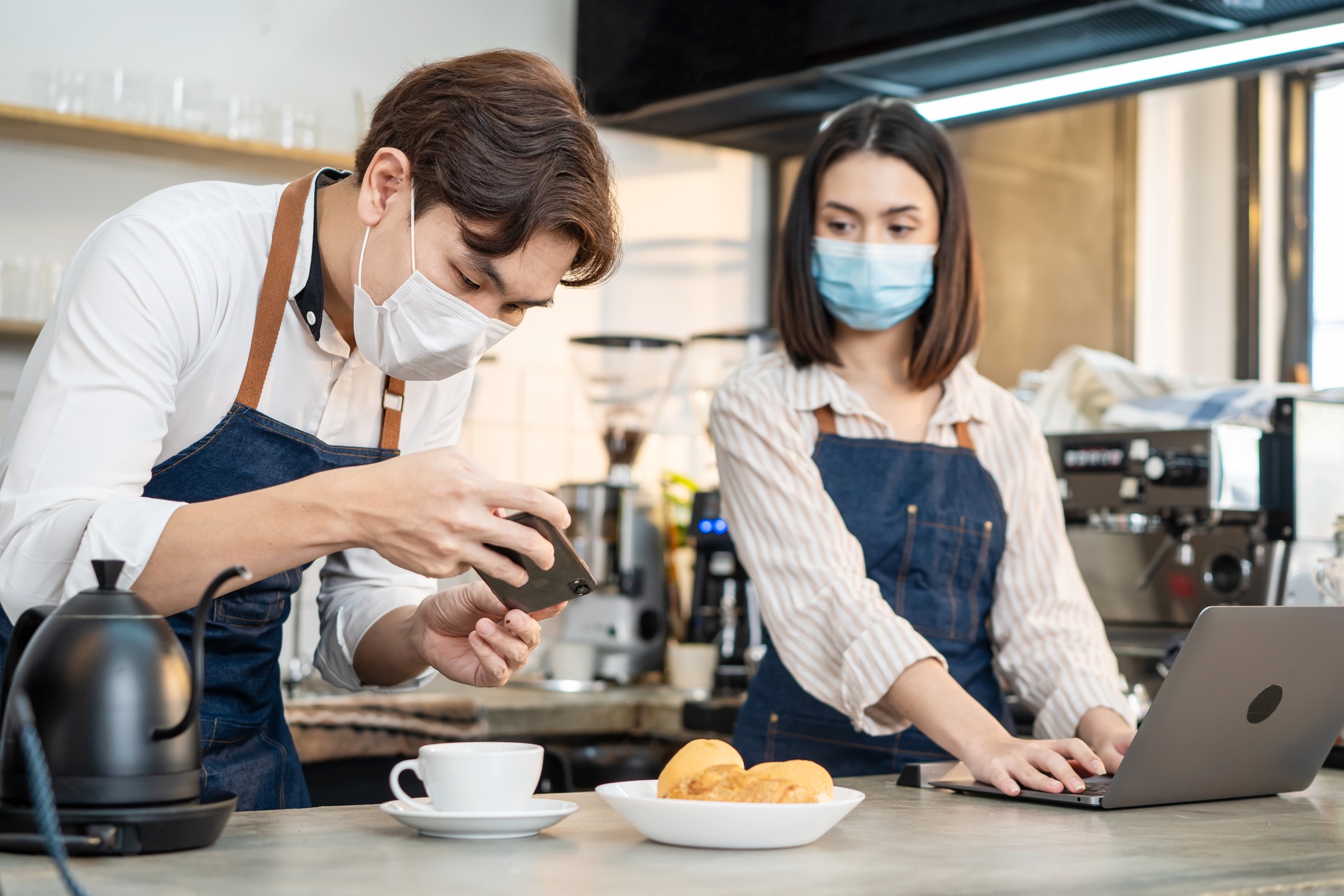 Asian business people take photo of coffee and post advertising content for social network