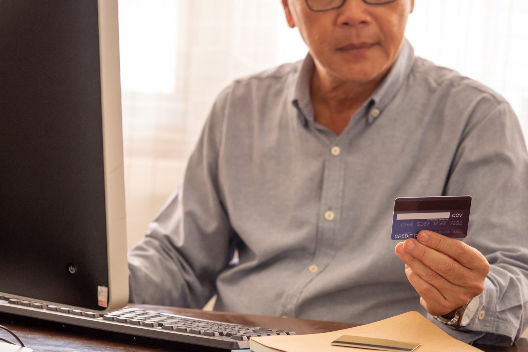 Asian businessman doing financial transactions by computer at the office room.