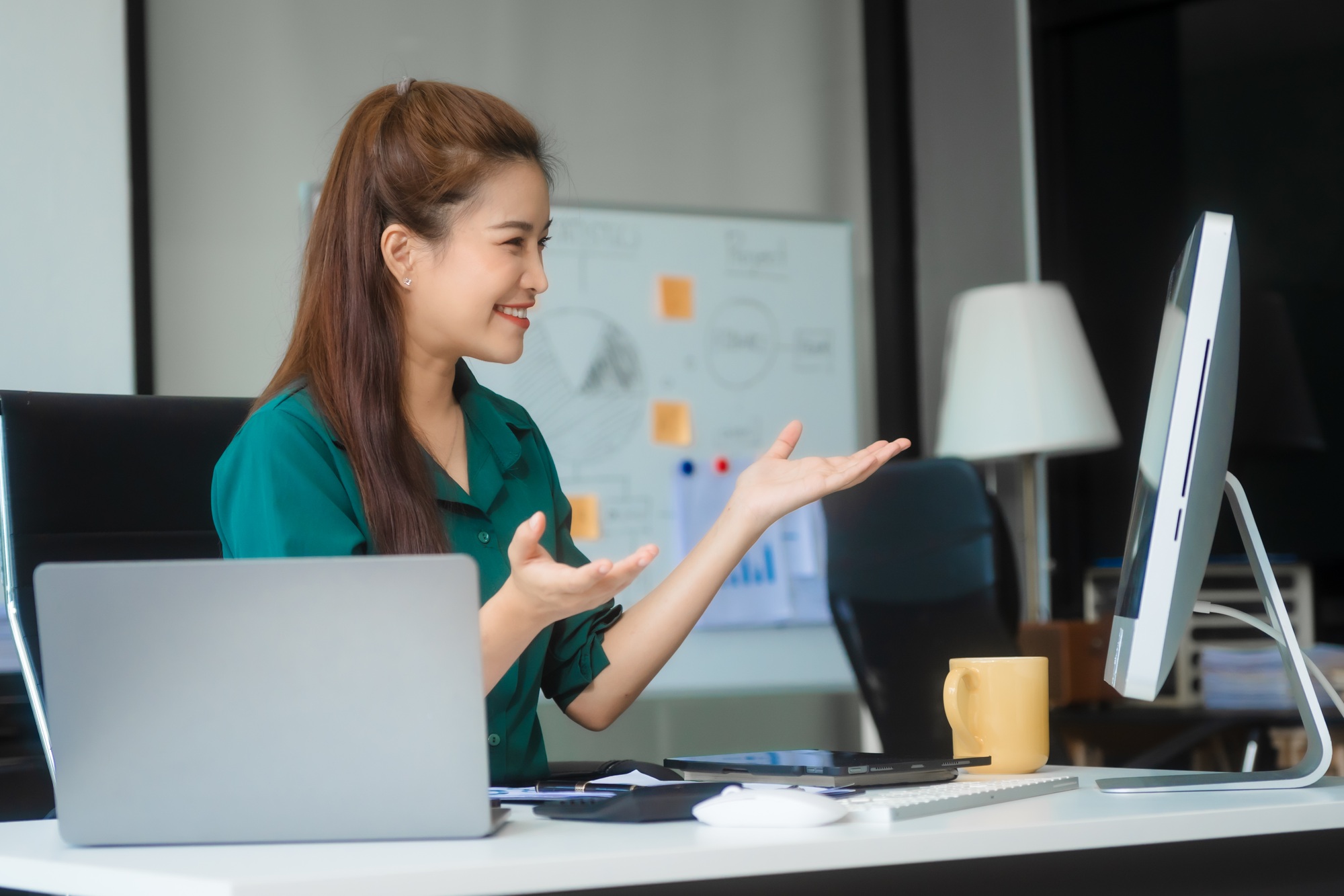 Asian businesswoman in formal attire works on laptop, on corporate law and marketing strategy.
